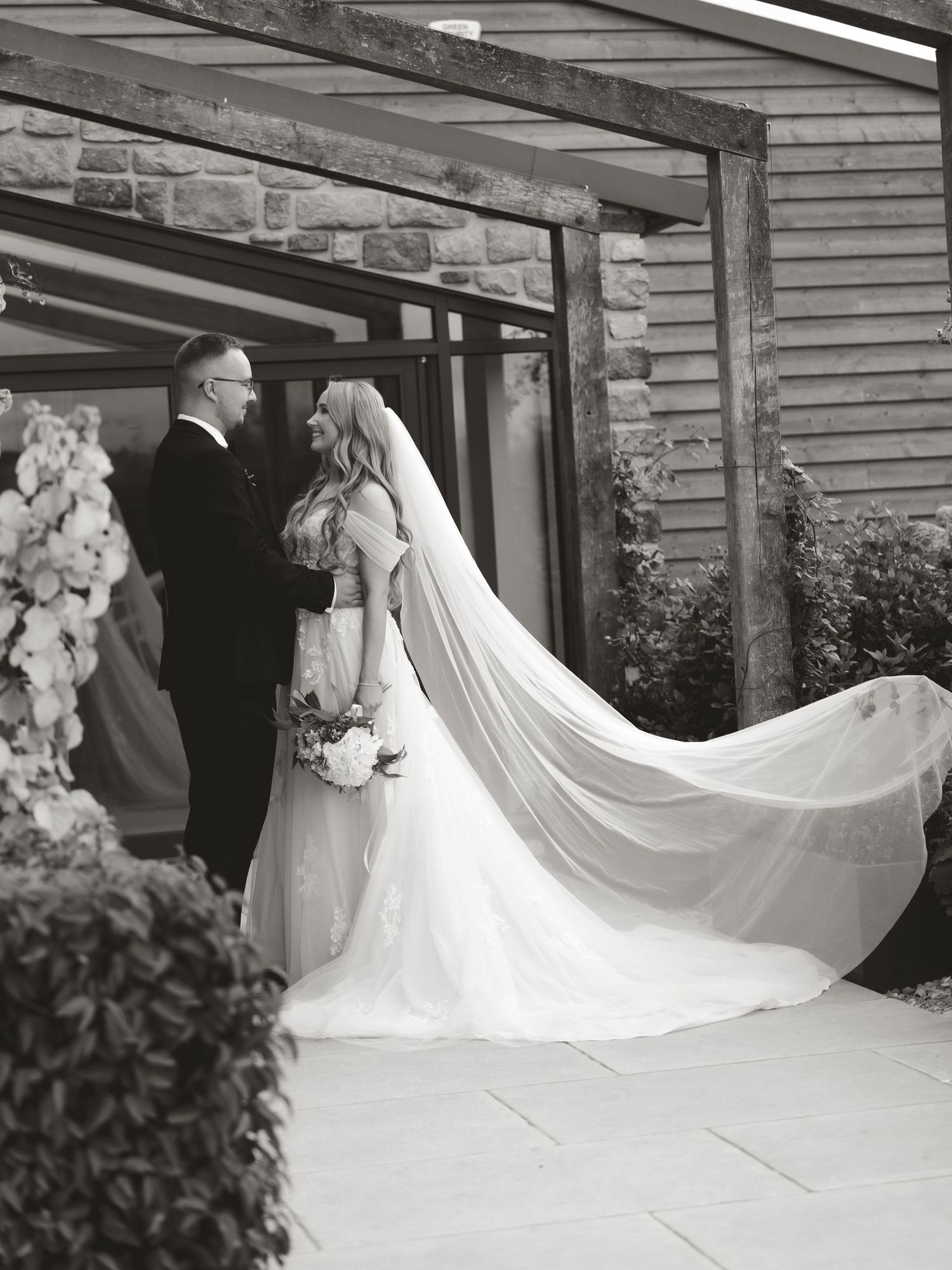 Wedding dress with flowing train photographed in sequence outside a rustic venue.