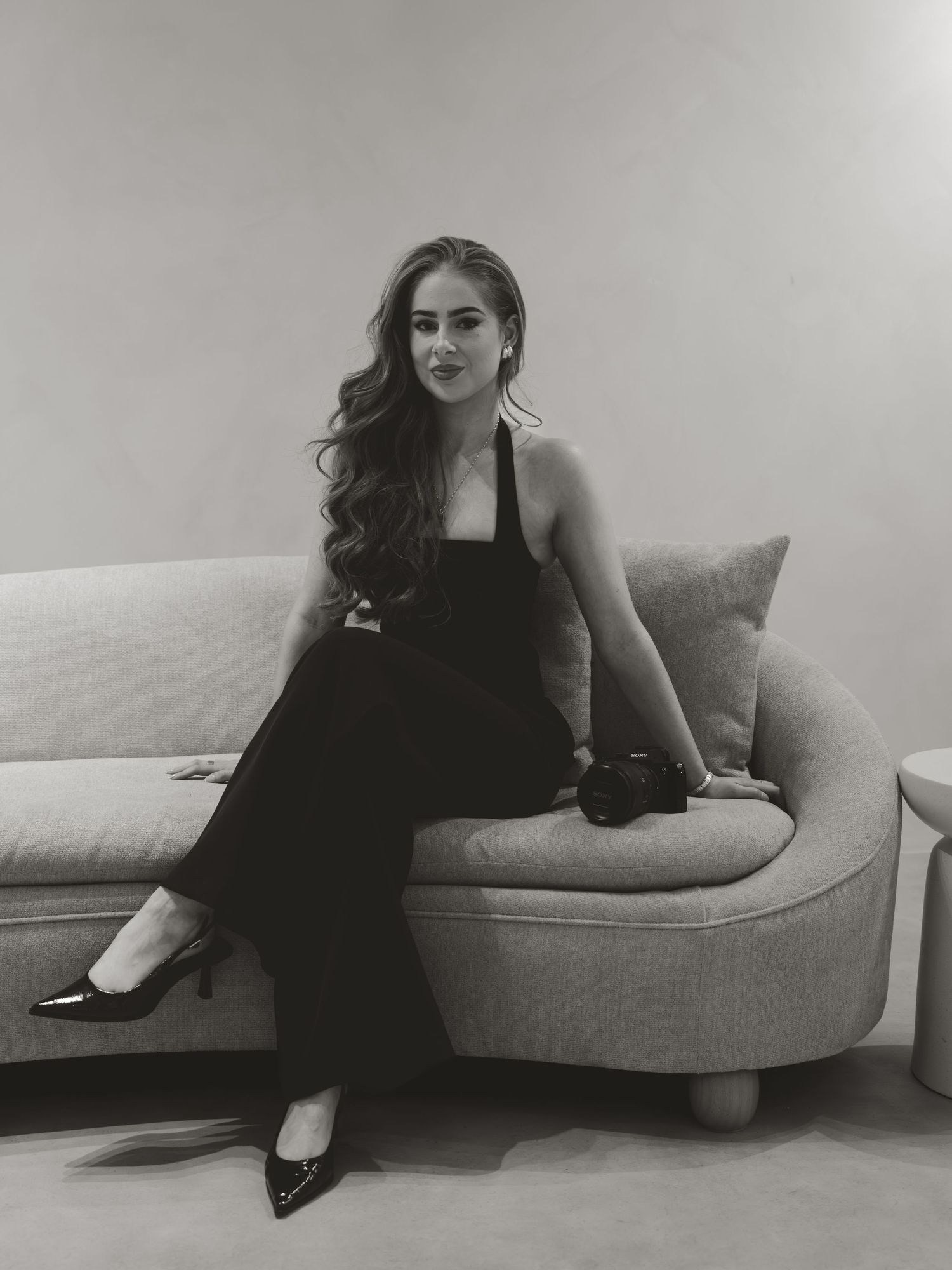 A series of artistic black and white photos showing a person lounging on a modern sofa.