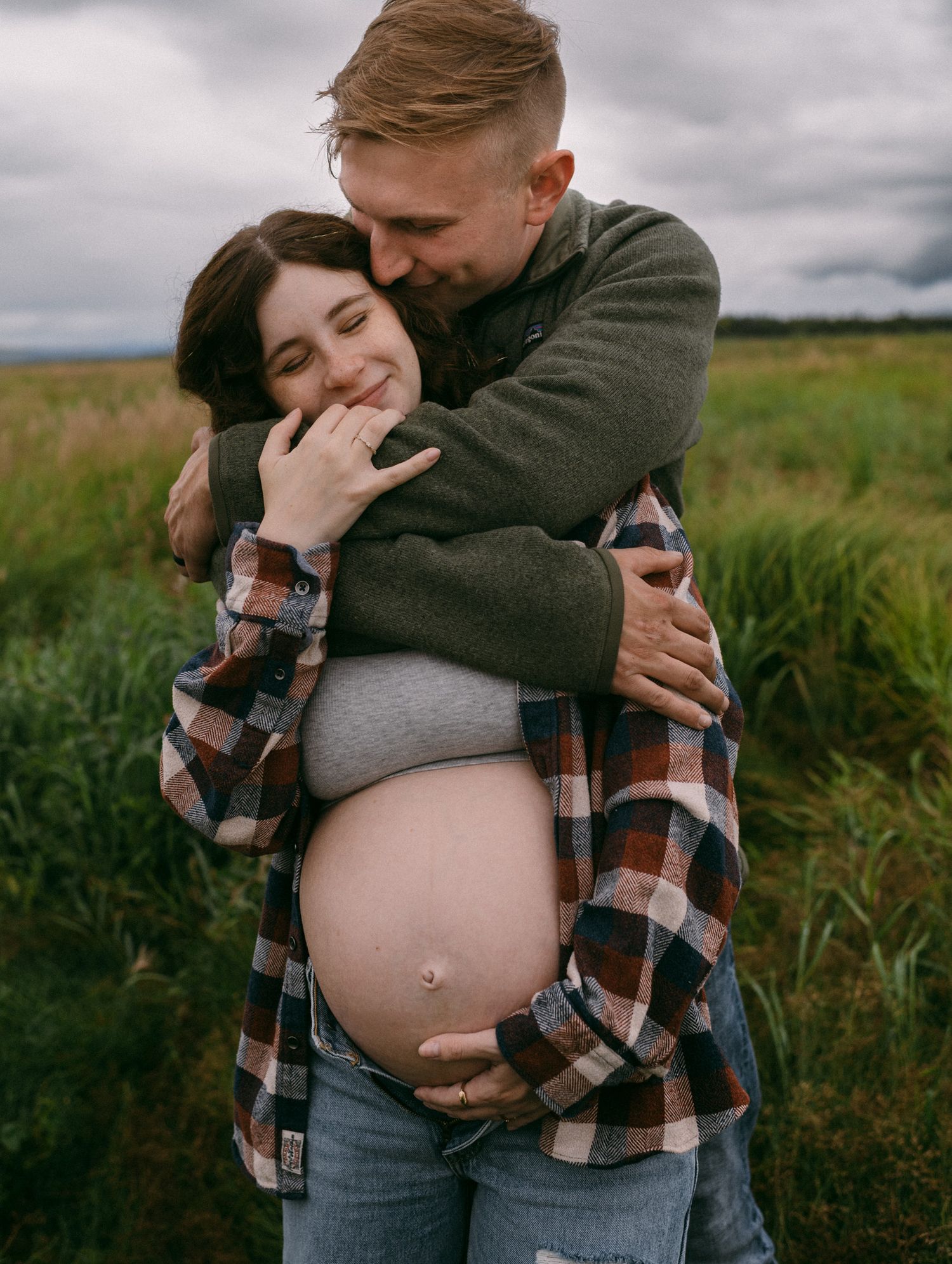 Maternity couple in green landscape near Fairbanks, Alaska.