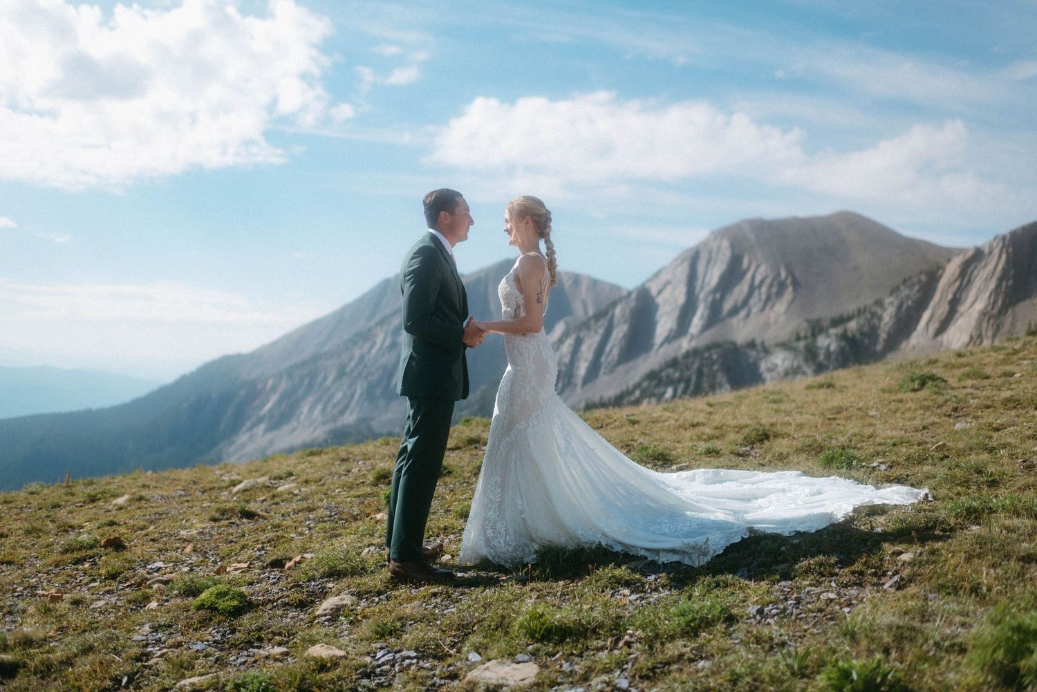 Couple saying their wedding vows in front of the mountains during a sunny day in Bozeman, Montana.