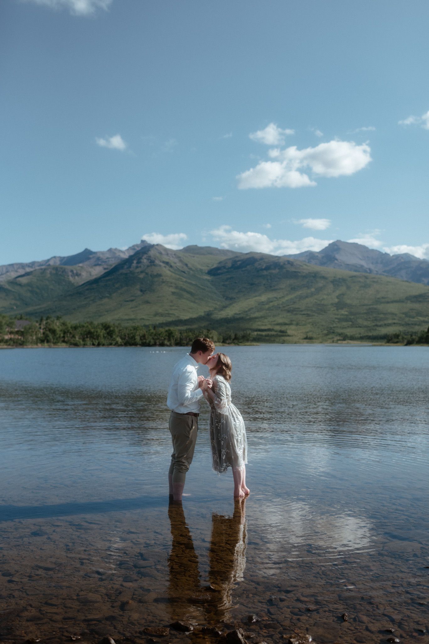 Intimate moment of a couple in the lake, surrounded by stunning Alaska mountains near Denali National Park on a hot summer day.