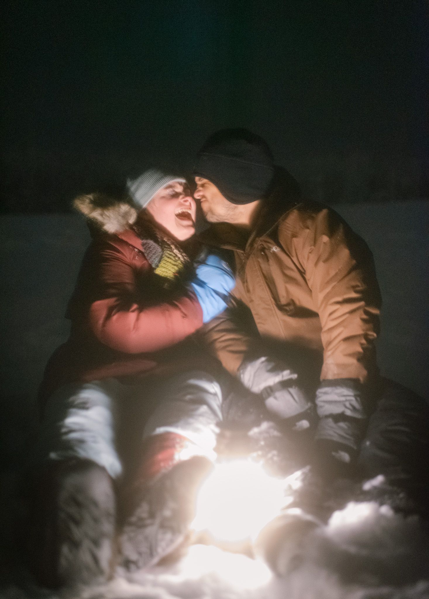 Engaged couple standing together under the northern lights in Fairbanks, Alaska, celebrating their love beneath the night sky.