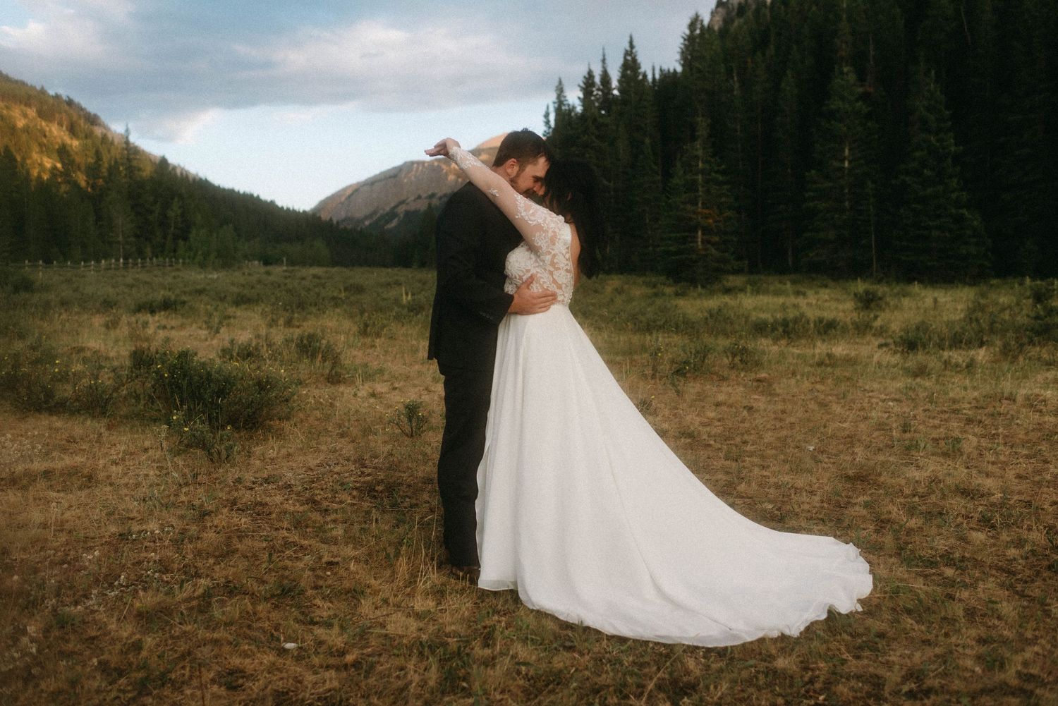 Bride and groom sharing intimate moments during their wedding in Big Sky, Montana, surrounded by mountains and trees.