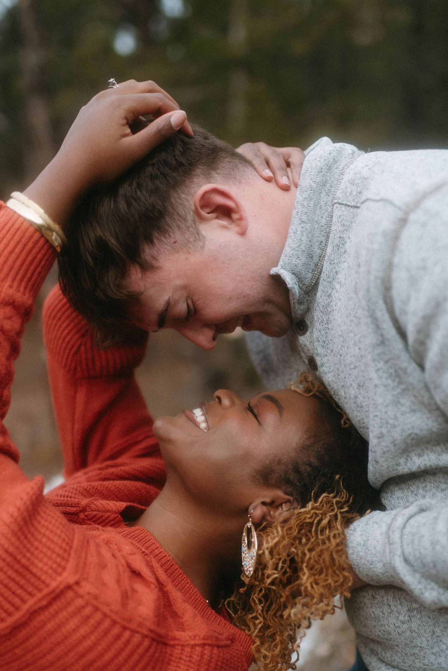 Authentic couple laughing and embracing during a playful engagement session on Montana State Land near Great Falls, Montana.