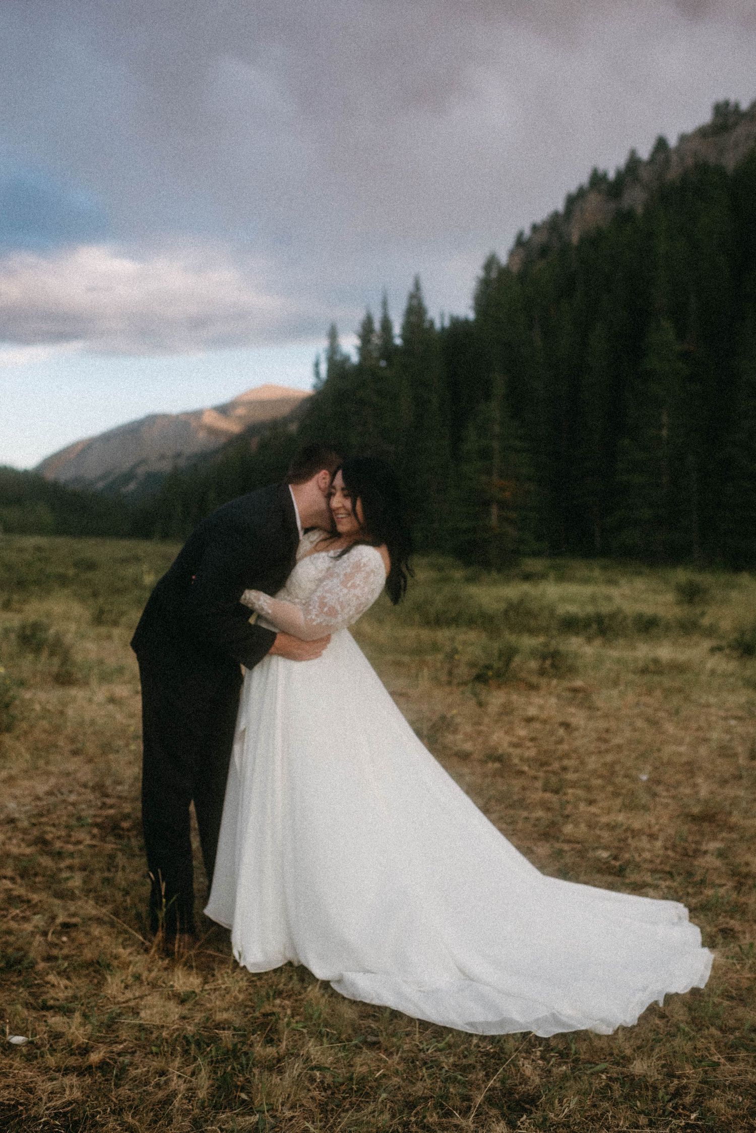 Candid wedding photography of bride and groom being playful in a wide Montana landscape