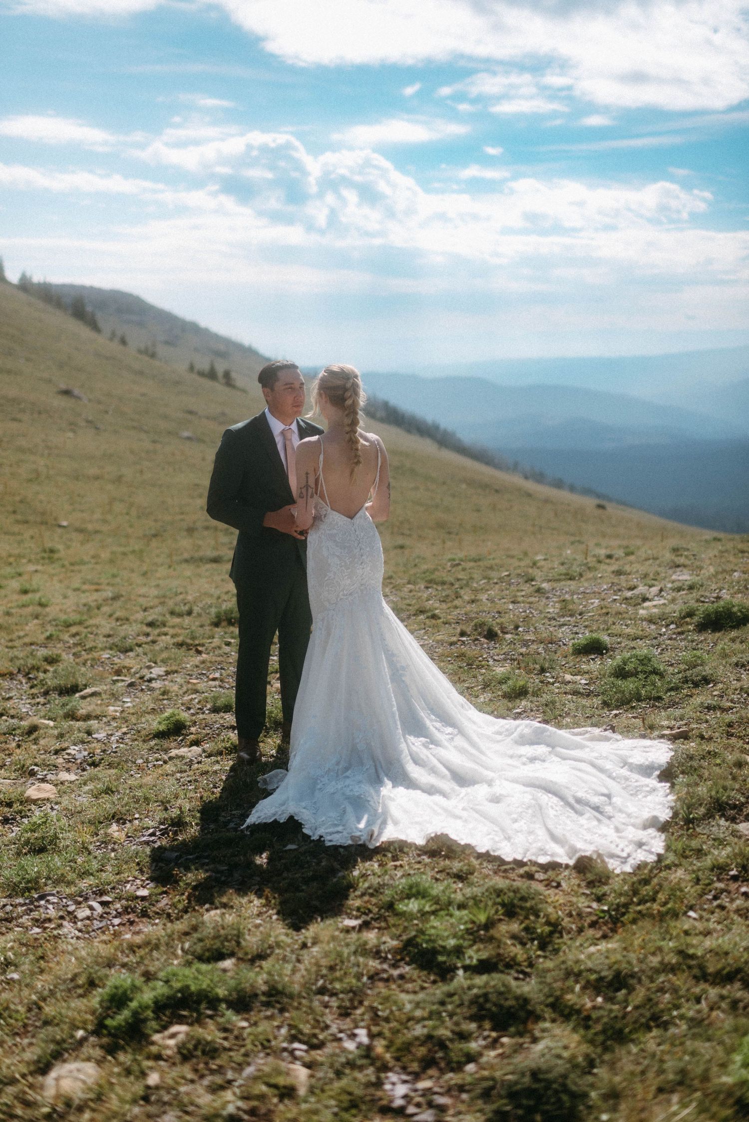 Bride and groom eloping on a sunny mountaintop near Bozeman, Montana, exchanging wedding vows during an intimate wedding ceremony.