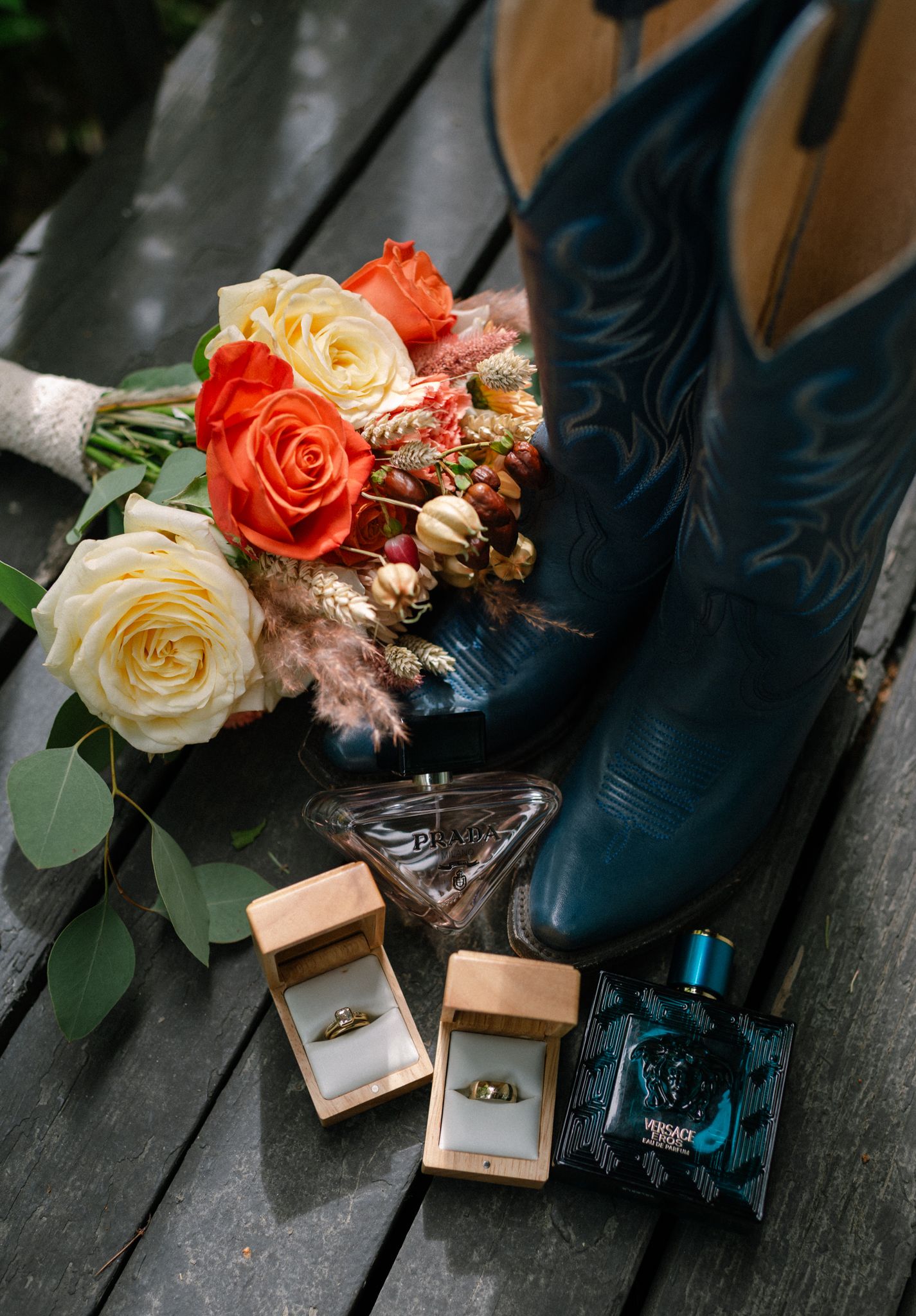 Fairbanks Alaska wedding photographer capturing wedding details with bridal bouquet, rings, cowboy boots, and perfume.