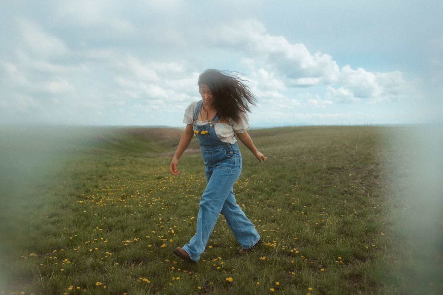 Self-portrait of a photographer walking through a field of wildflowers in Great Falls, Montana, with wind in her hair.