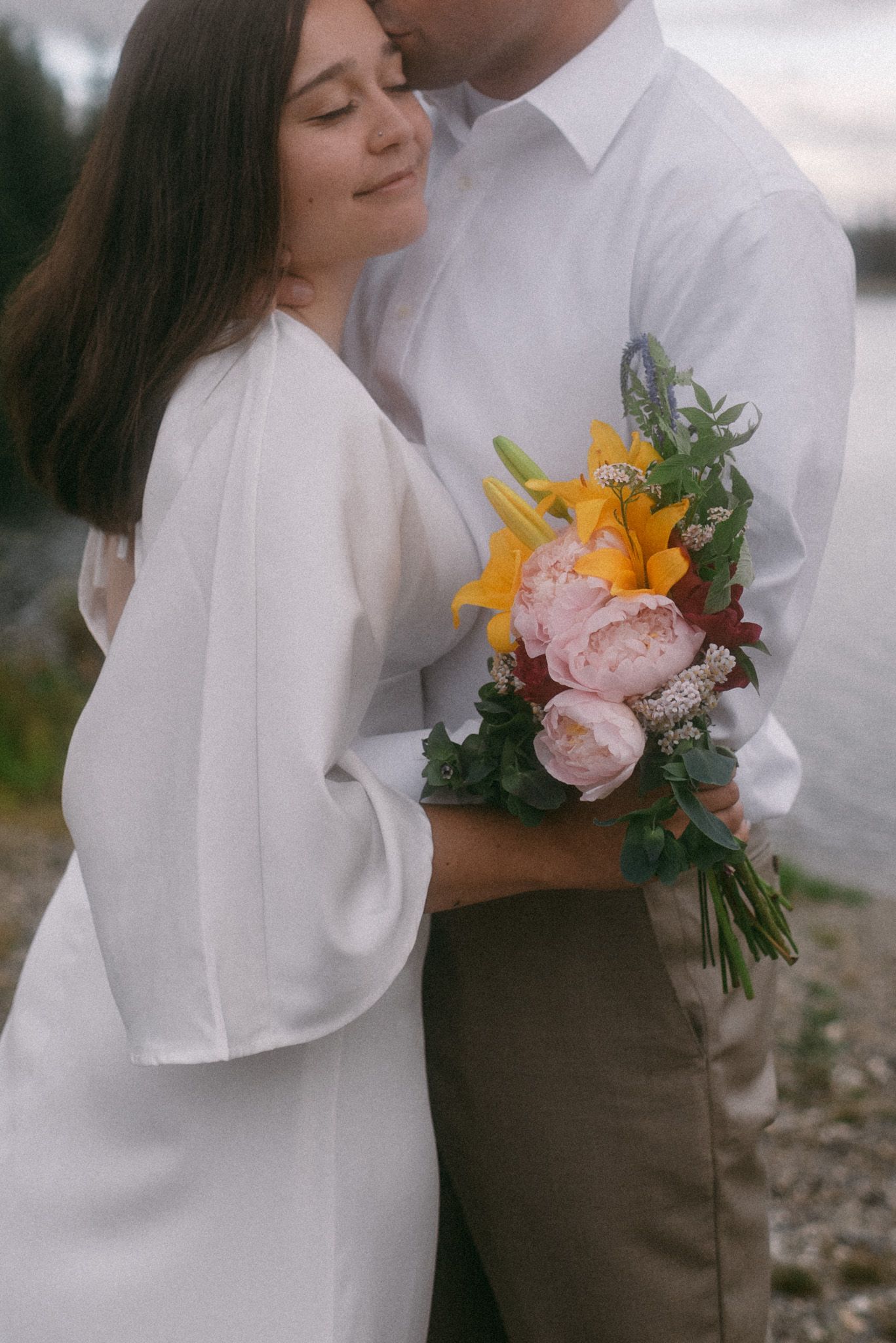 ride and groom on their elopement day with close-up floral details in Alaska.