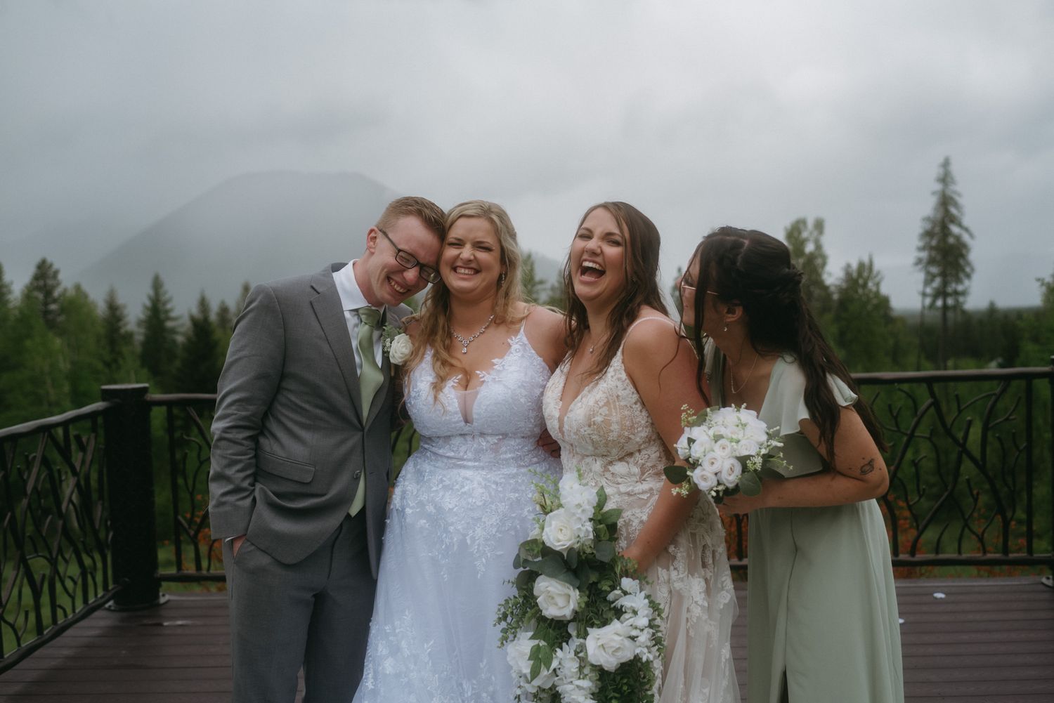 Bride’s close friends and family laughing during conversation in front of the mountains in Glacier National Park, Montana.