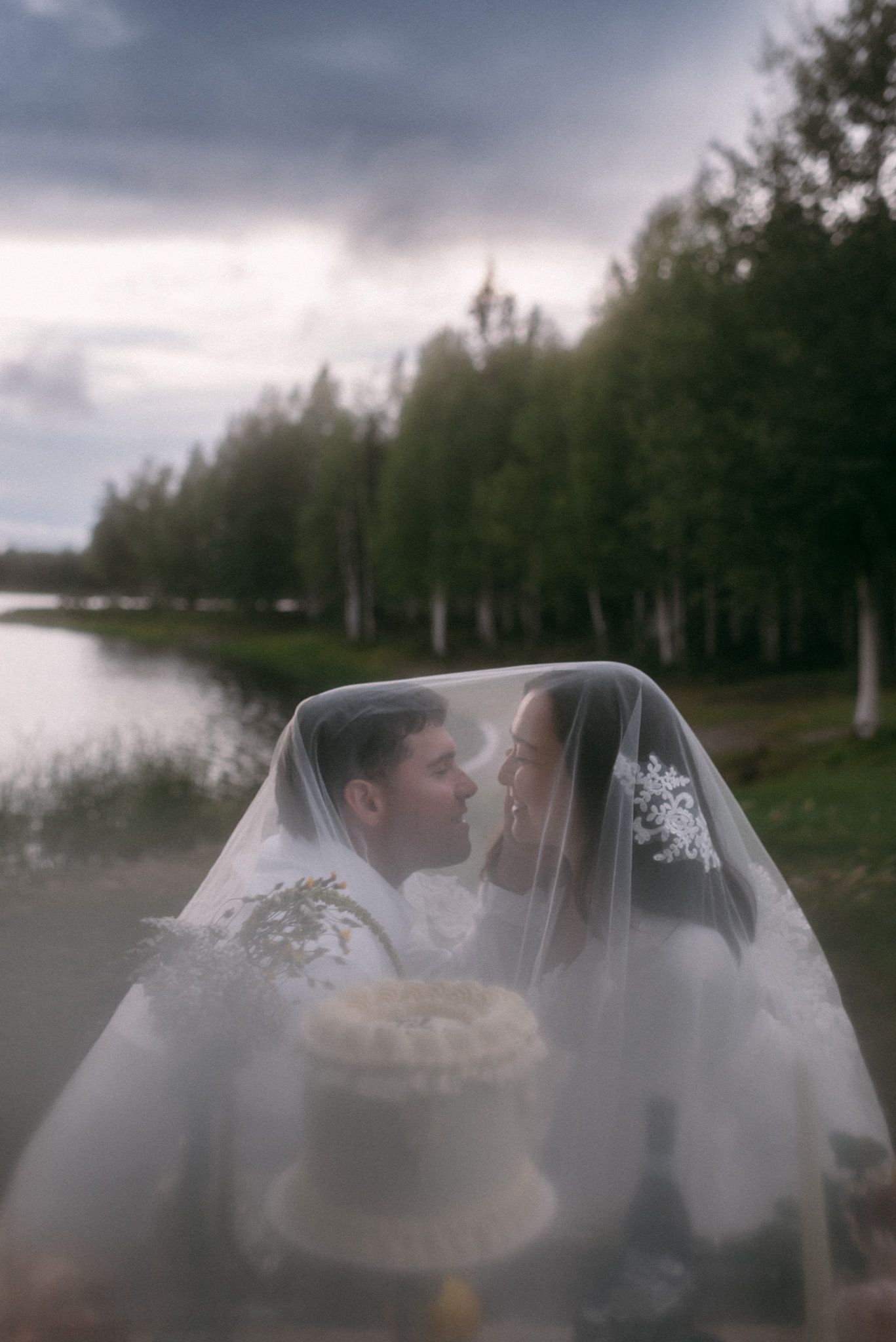 Bride and groom sharing an intimate moment near the river during their elopement picnic in Alaska.