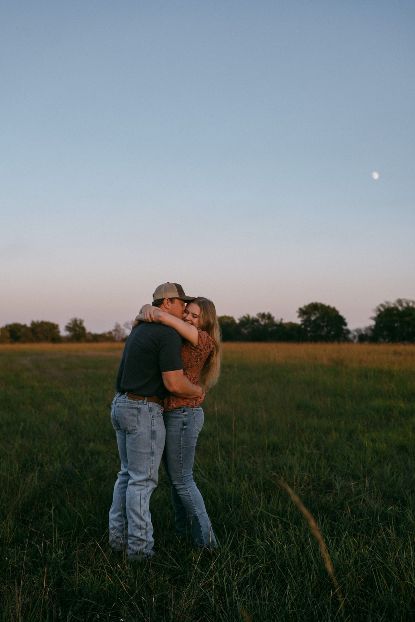 Engagement session celebrating love in Wichita, Kansas, surrounded by lush greenery during golden hour.