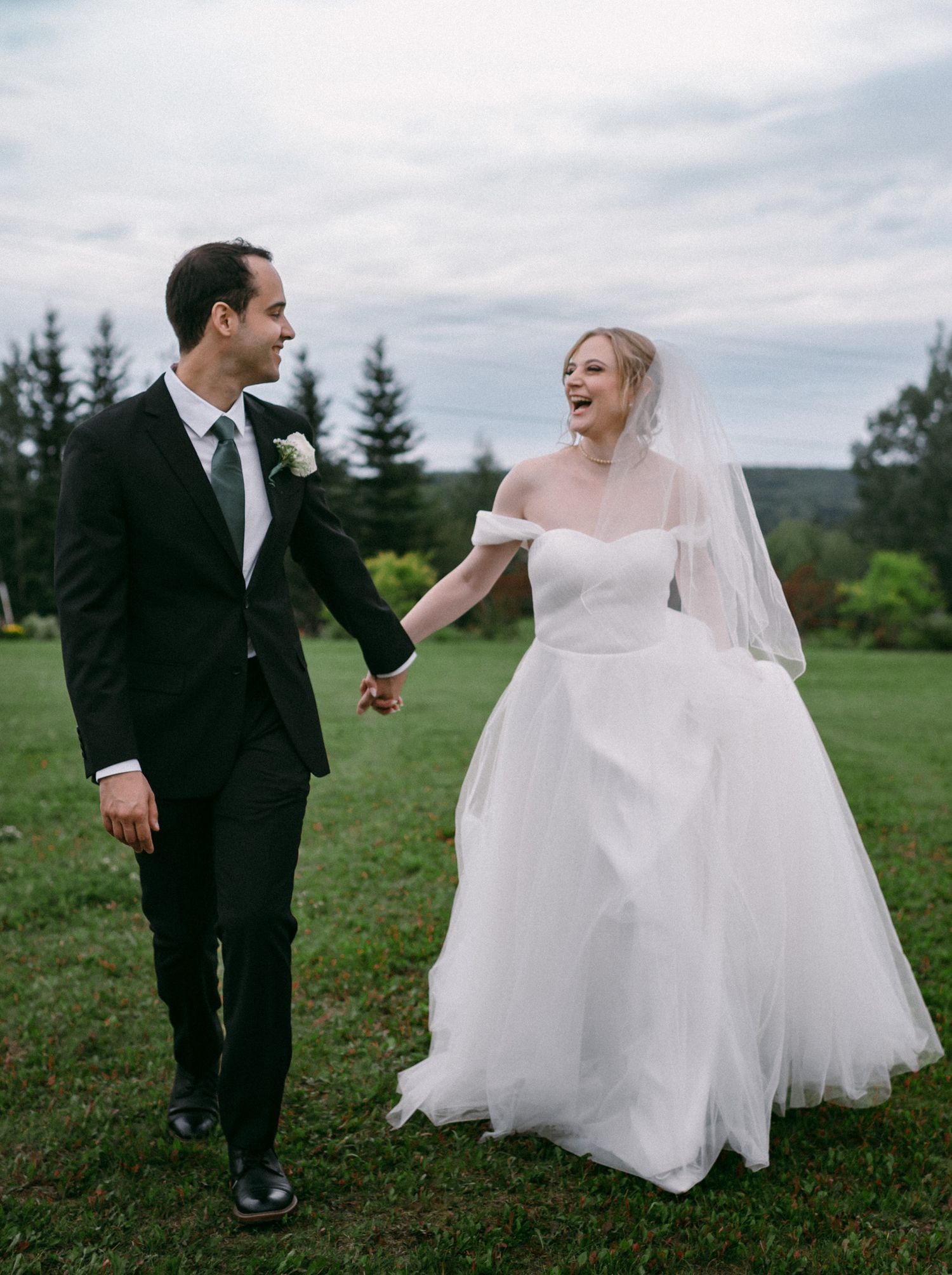 Wedding couple walking hand in hand through a garden, enjoying the summer weather in Fairbanks, Alaska.