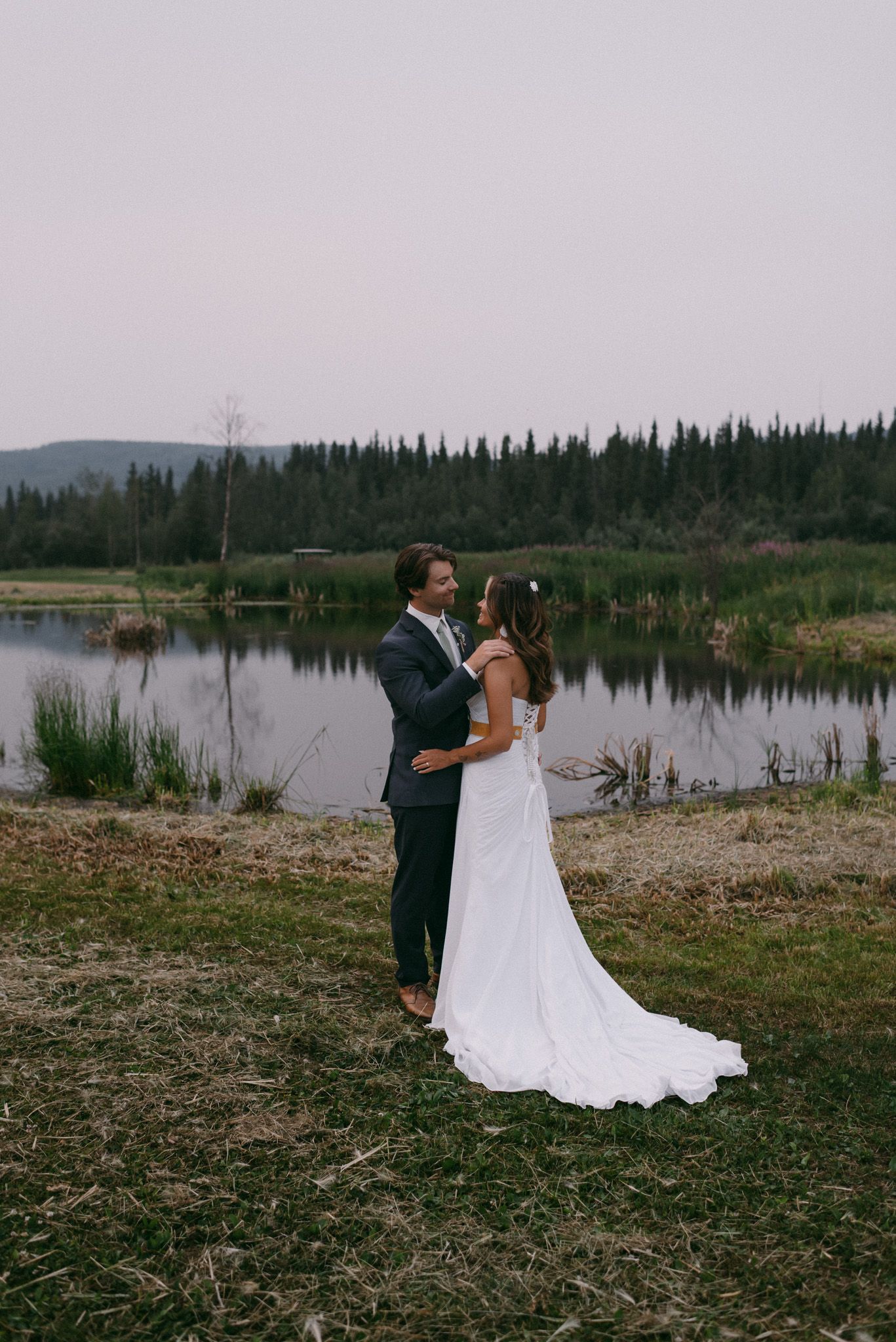 Wedding couple enjoying a quiet, intimate moment while facing each other at Midnight Sun Golf Course in Fairbanks, Alaska.
