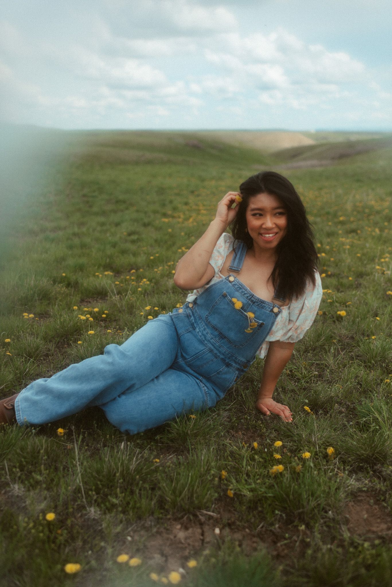Self-portrait of a wedding photographer sitting among wildflowers in the landscape near Great Falls, Montana.
