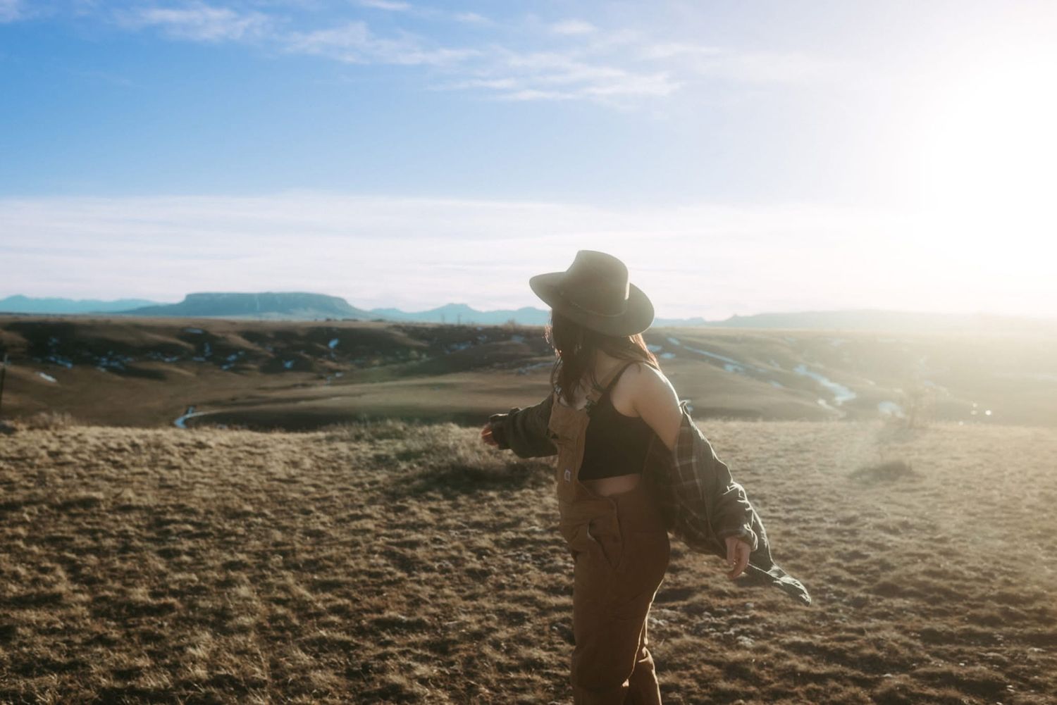 Self-portrait of a photographer in Montana embracing her roots, soaking up the sun with wind in her hair while viewing Square Butte.