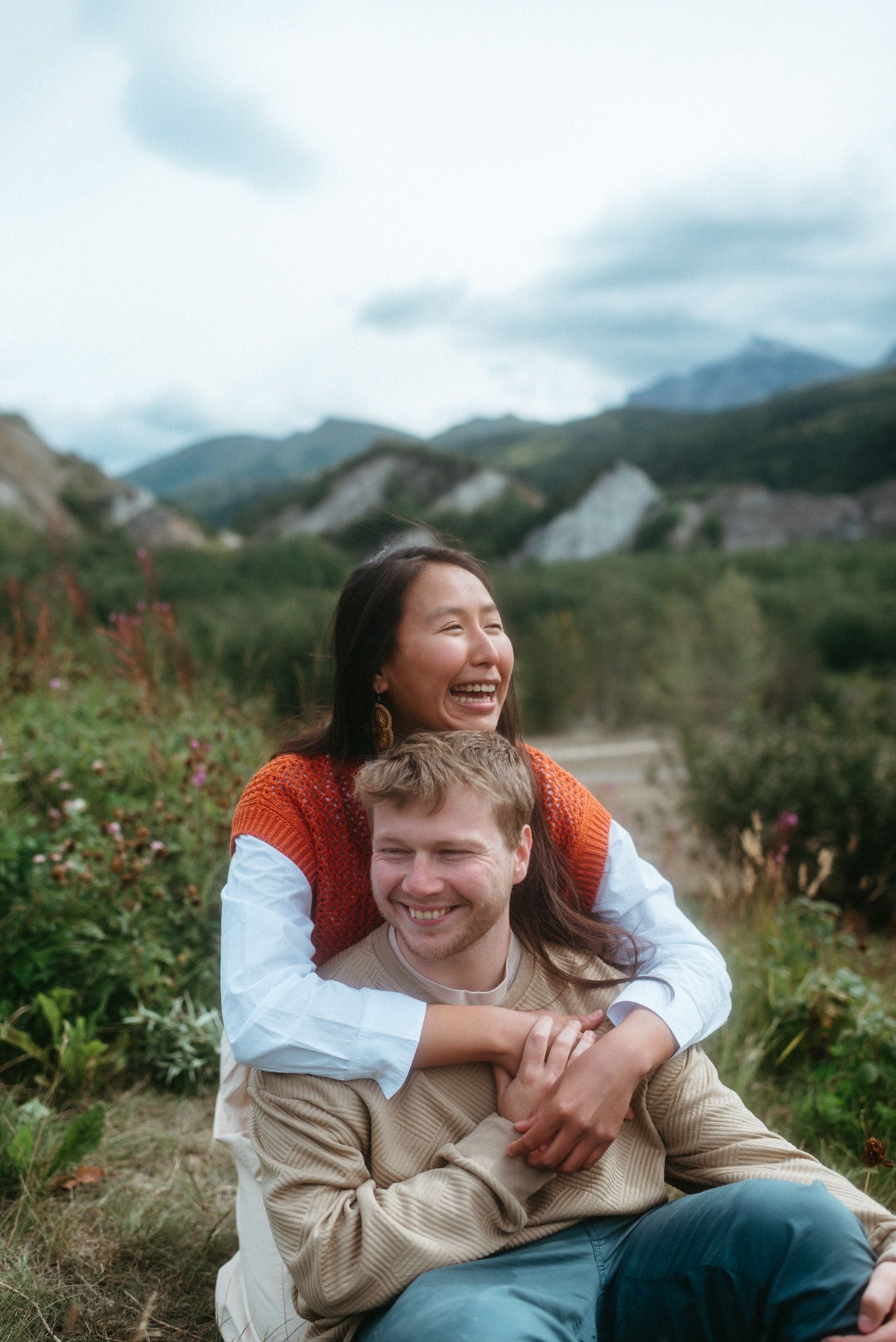 Couple in a loving embrace with a stunning mountain view during summer near Denali National Park, Alaska.