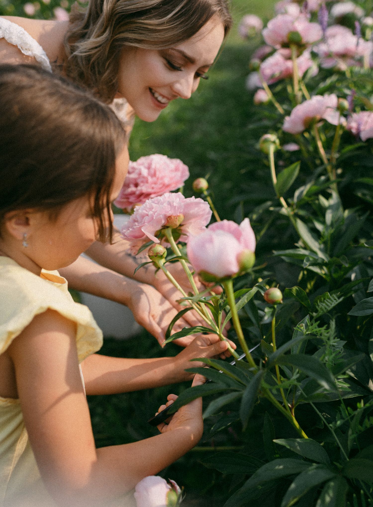 A mother-and-me portrait outside Fairbanks, Alaska, surrounded by beautiful peonies on a perfect day for bonding and capturing memories.