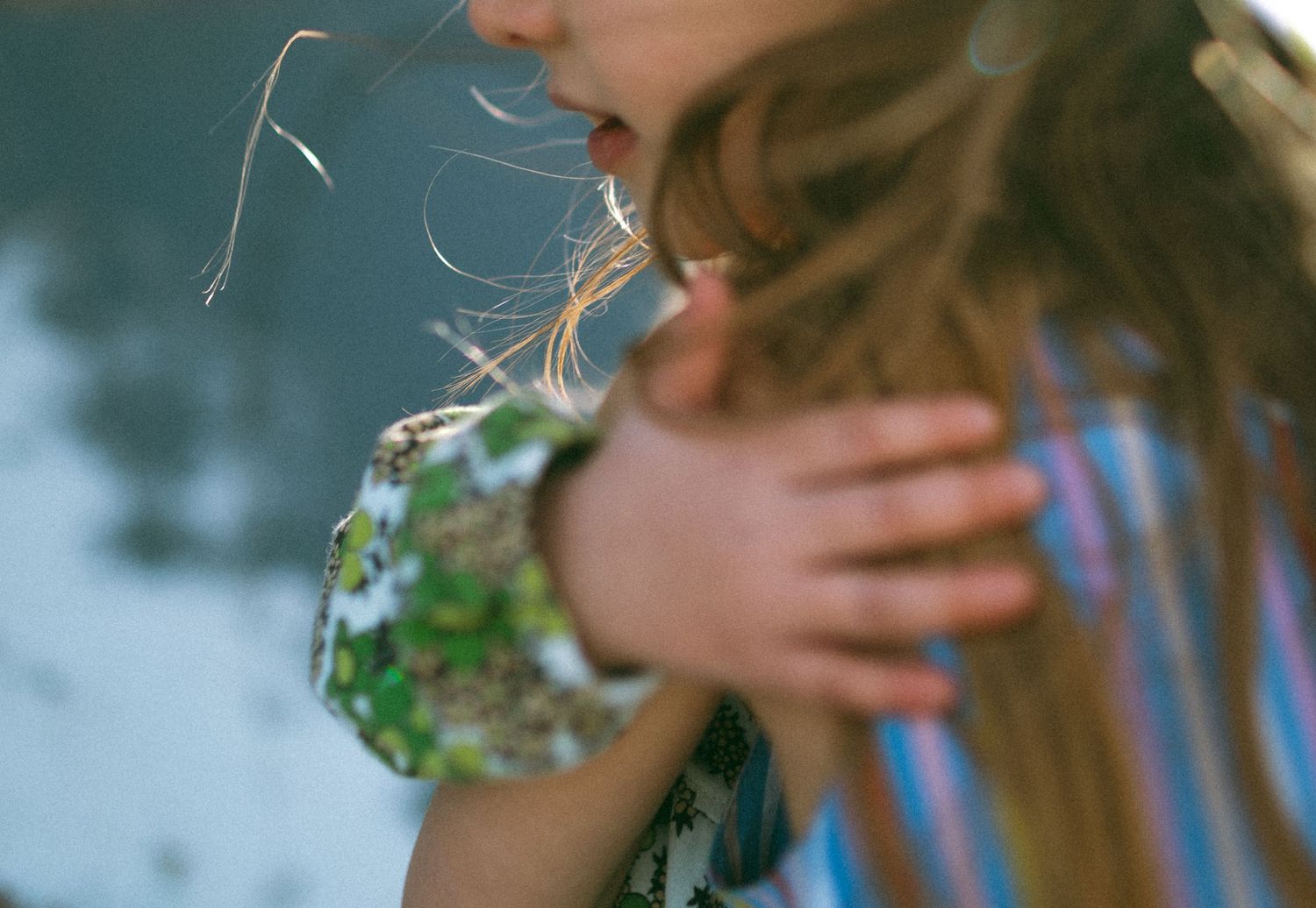 hugging sisters find out playing for their family session is way better than a boring smile