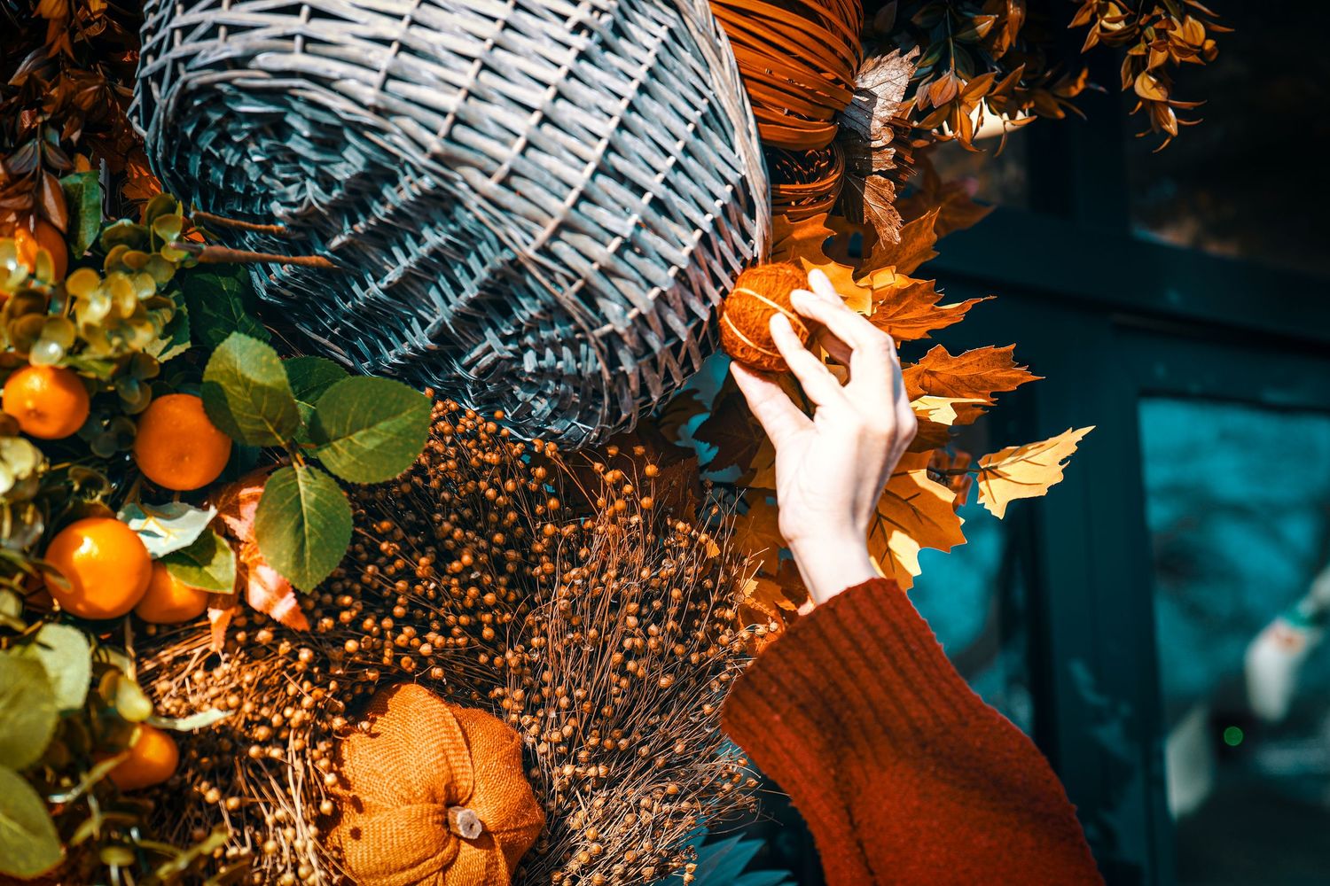Glittering disco ball reflects orange light while surrounded by citrus fruits and autumn leaves in moody lighting.