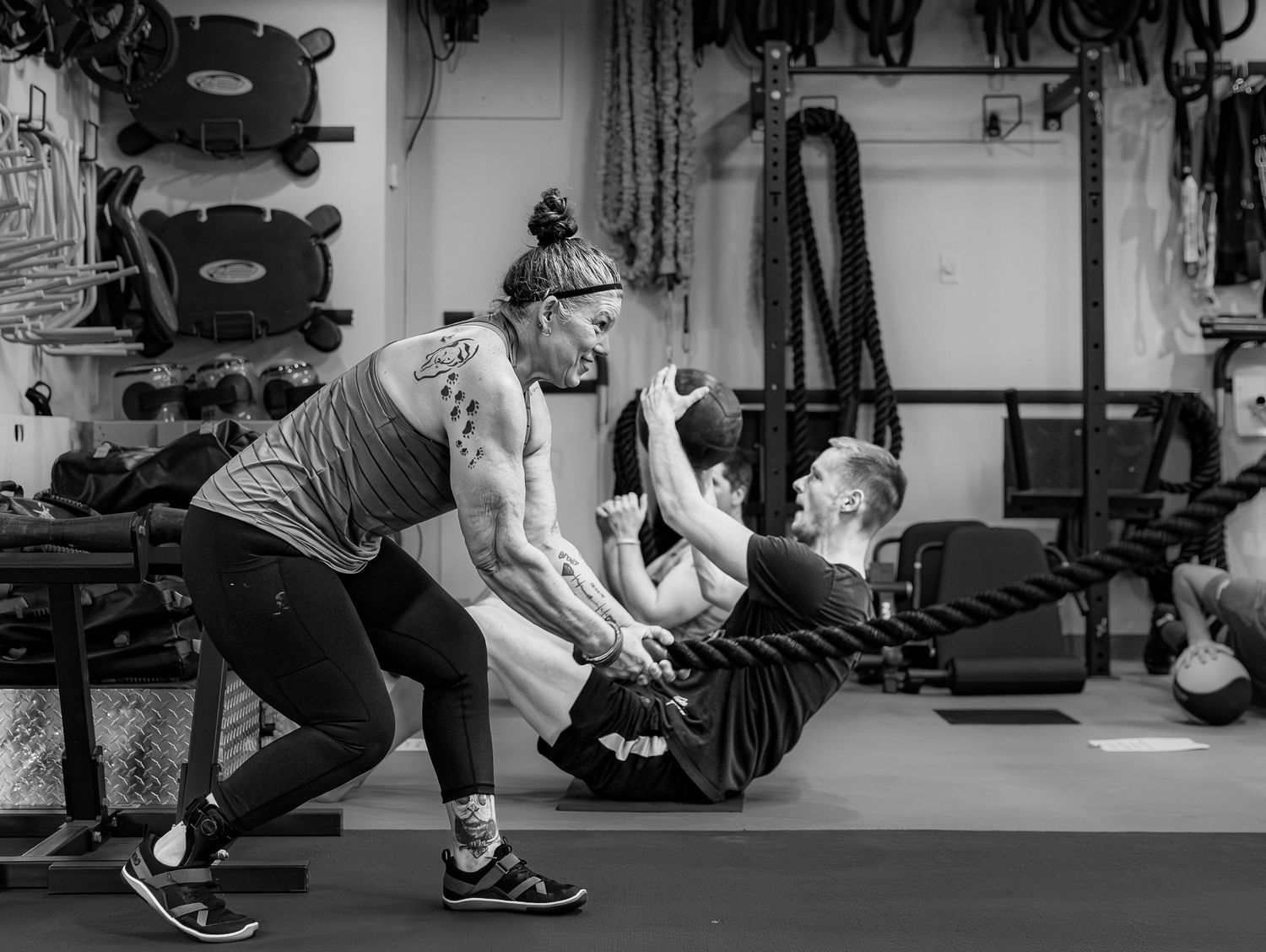 Black and white photo of two women working out together in a gym.