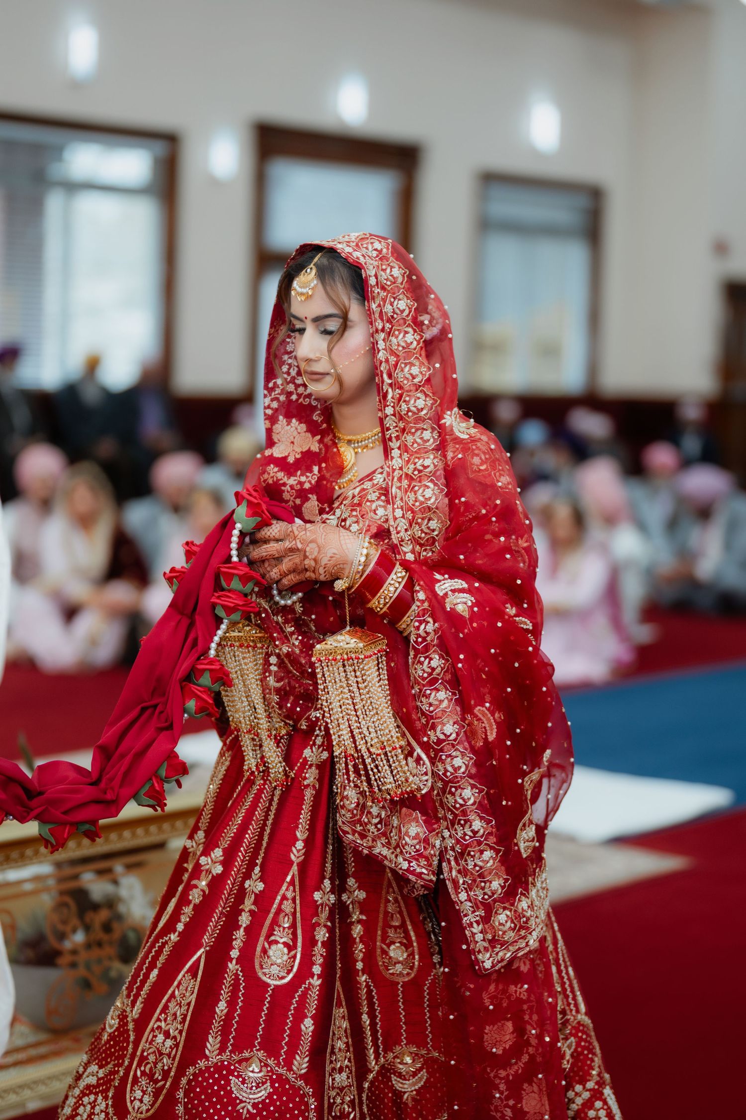 Traditional South Asian wedding ceremony with detailed red bridal attire and gold accessories.