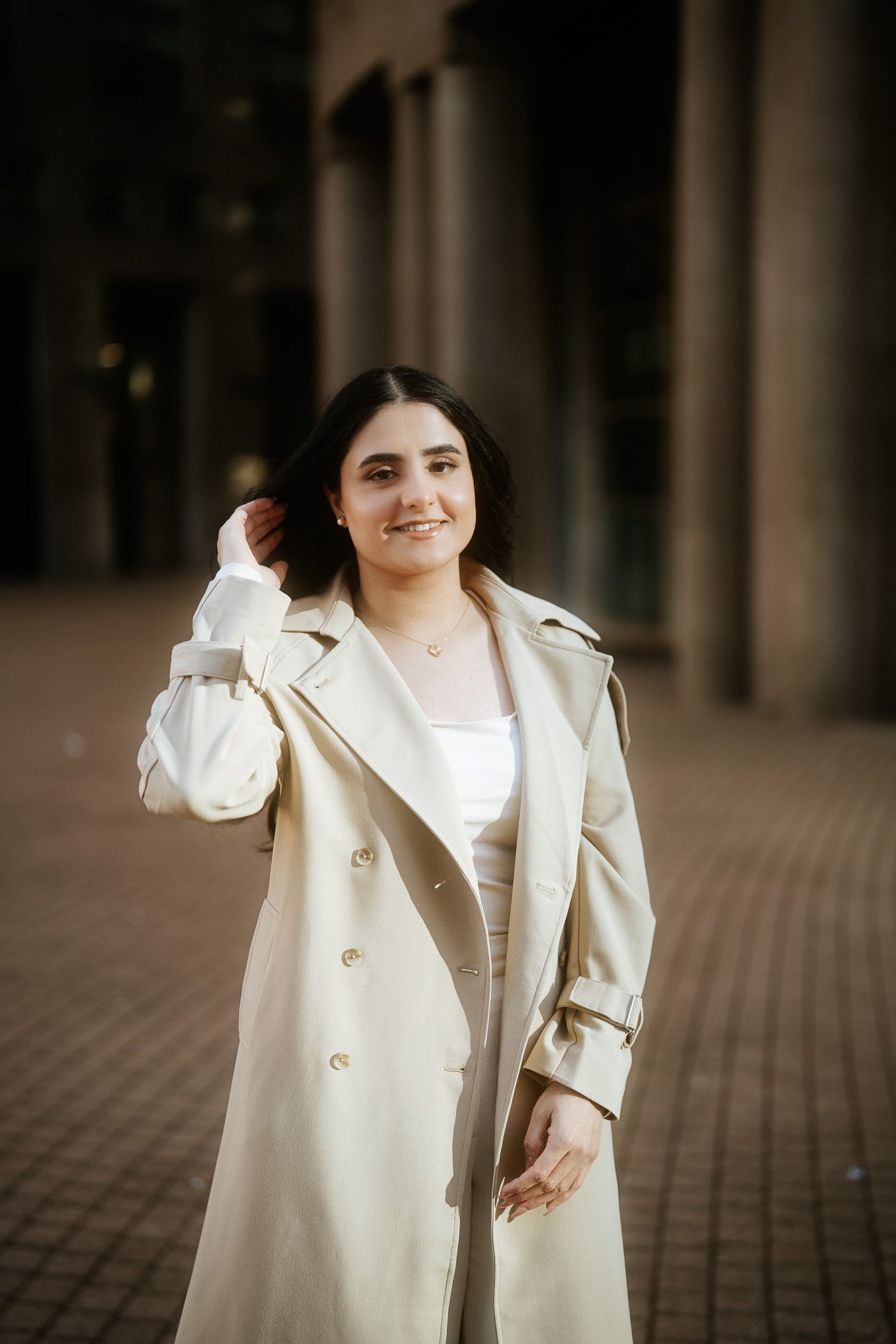 A collection of warm-toned photos featuring someone wearing a cream-colored coat against an architectural backdrop.