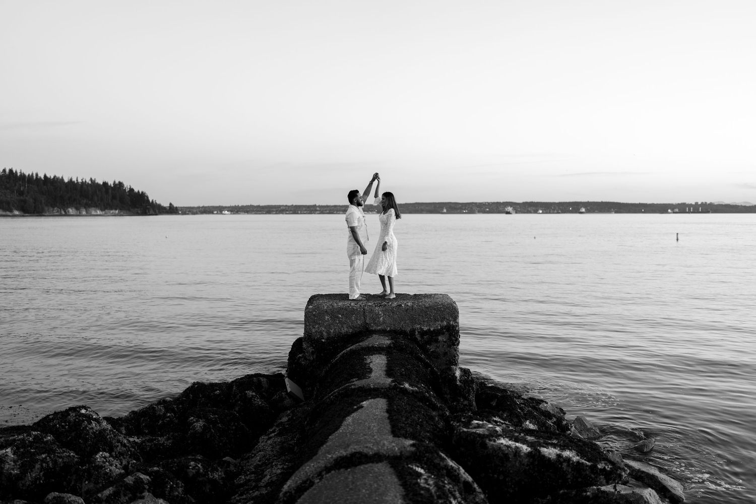 A series of black and white coastal photographs showing boats, docks, and waterfront scenes along a tranquil shoreline.