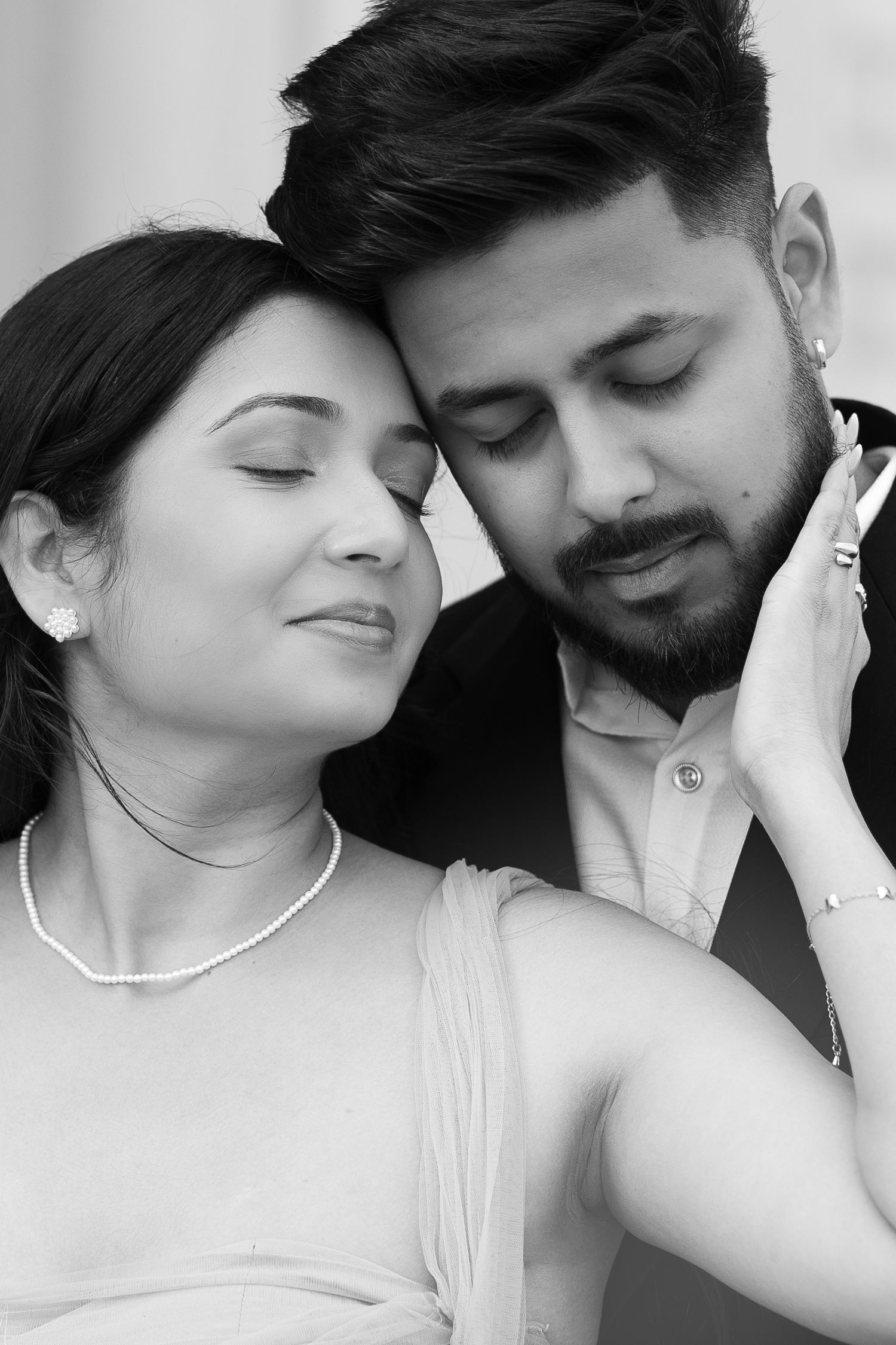 Black and white close-up portrait of couple sharing tender moment.