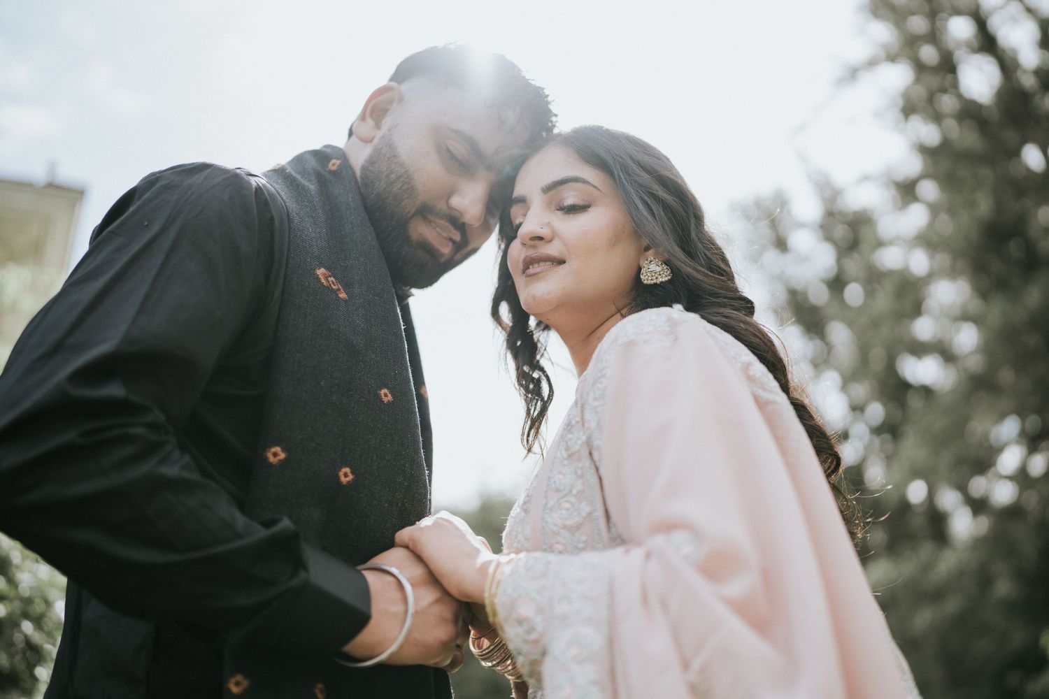 A romantic scene unfolds on a sunny day between two people dressed in black and pink.