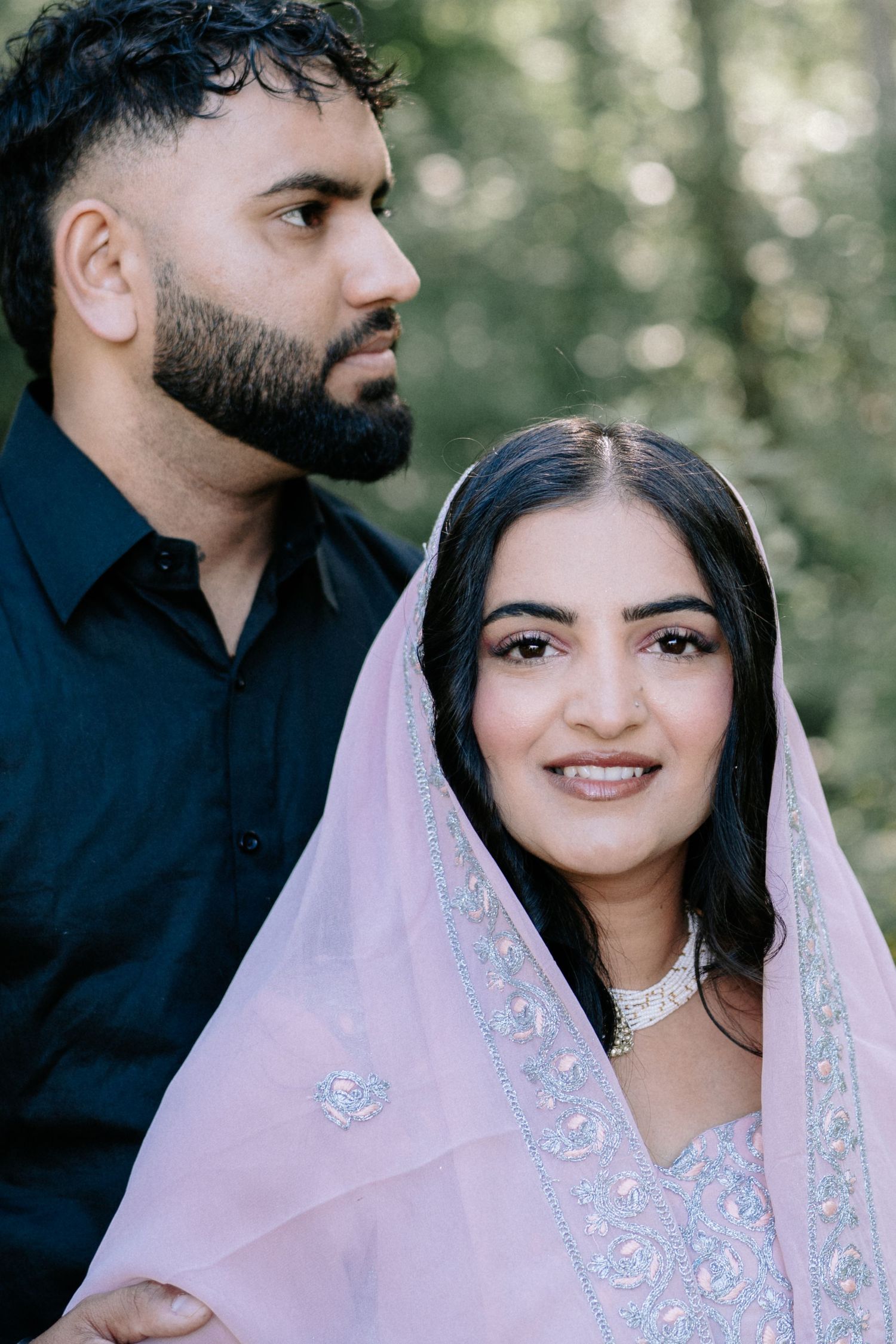 Couple in traditional attire sharing an intimate moment outdoors.