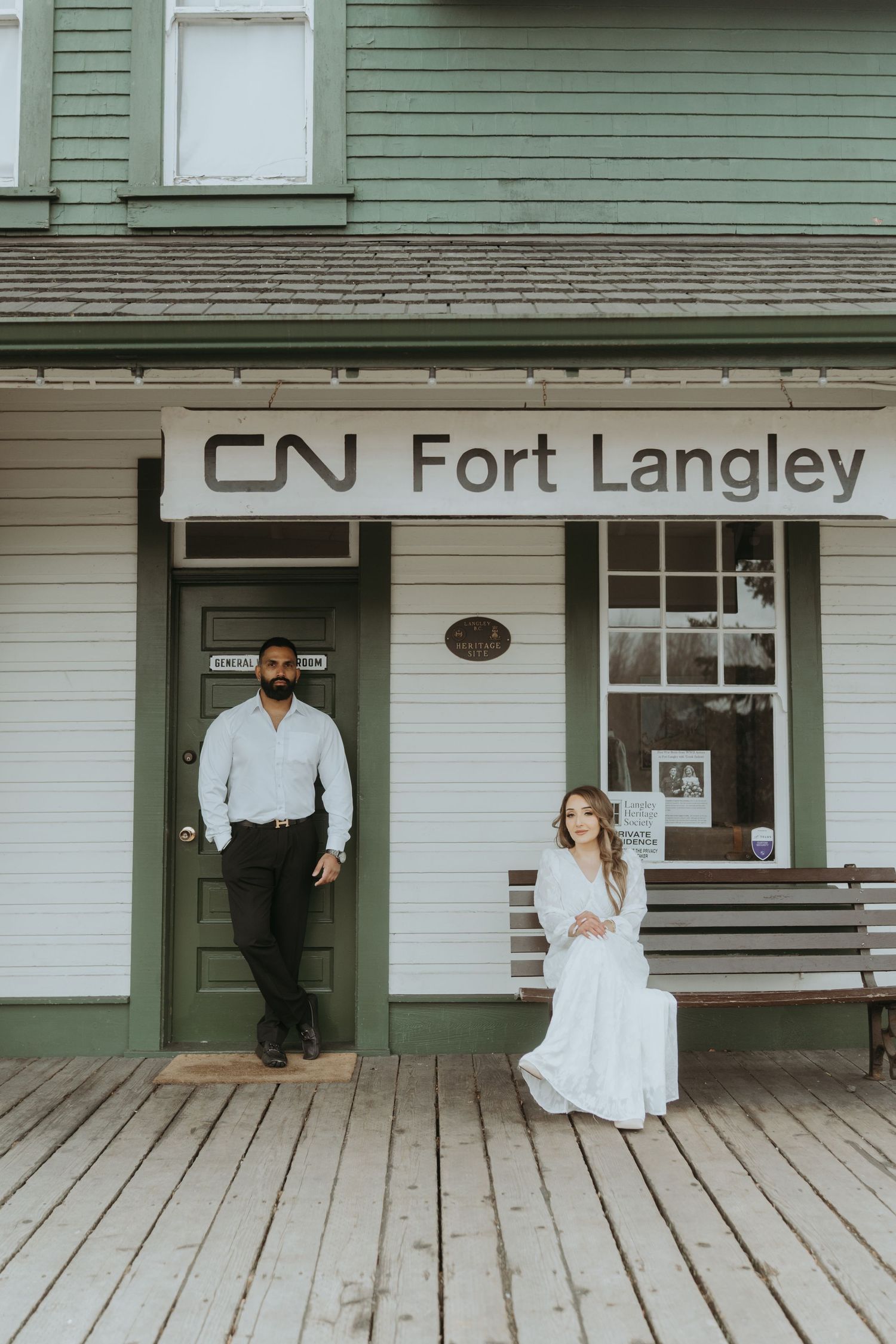 Historic CN Fort Langley station platform with wooden deck and green-trimmed building facade.