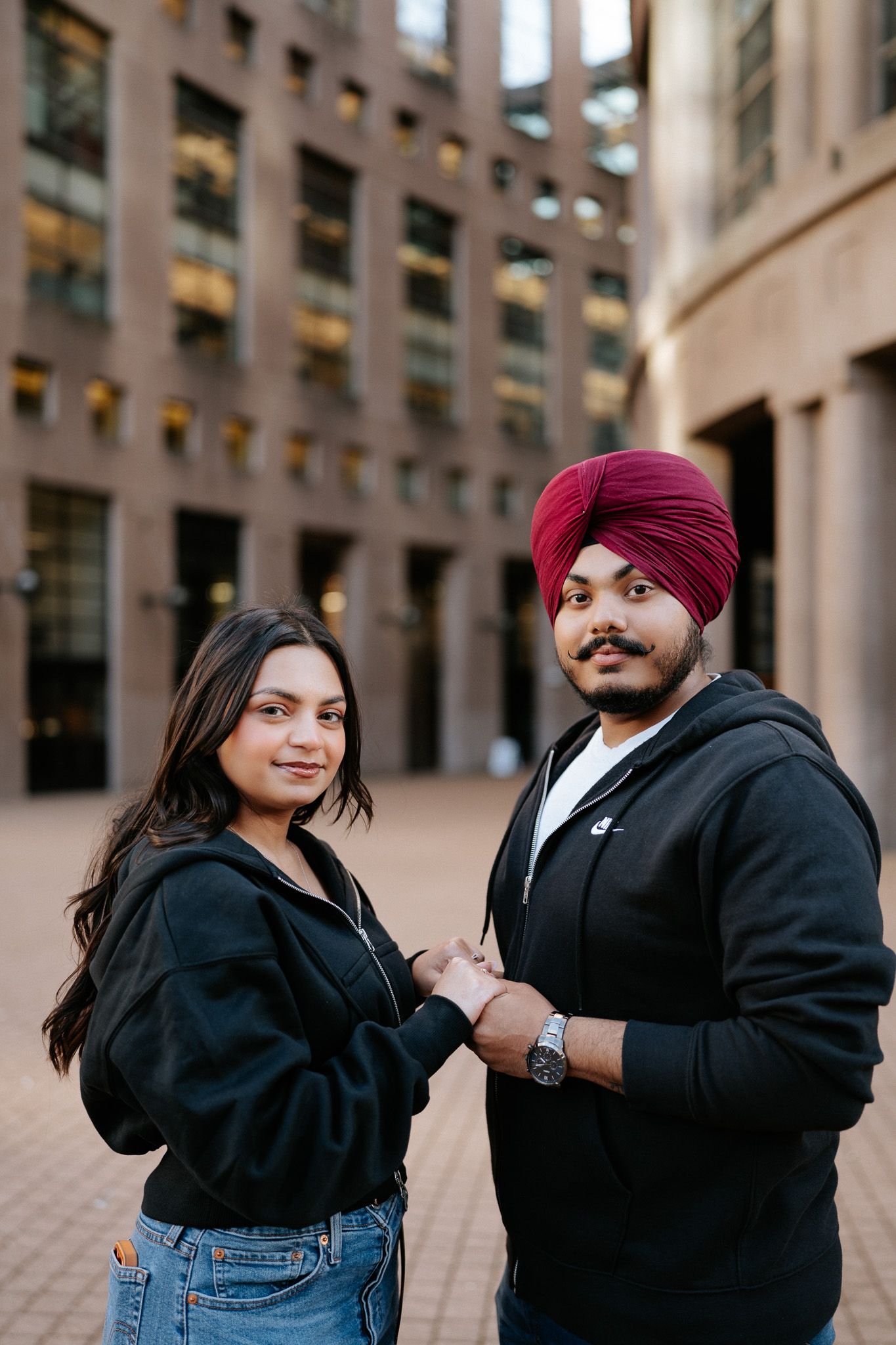 A couple in casual attire shares romantic moments in a series of candid photos against an urban backdrop.