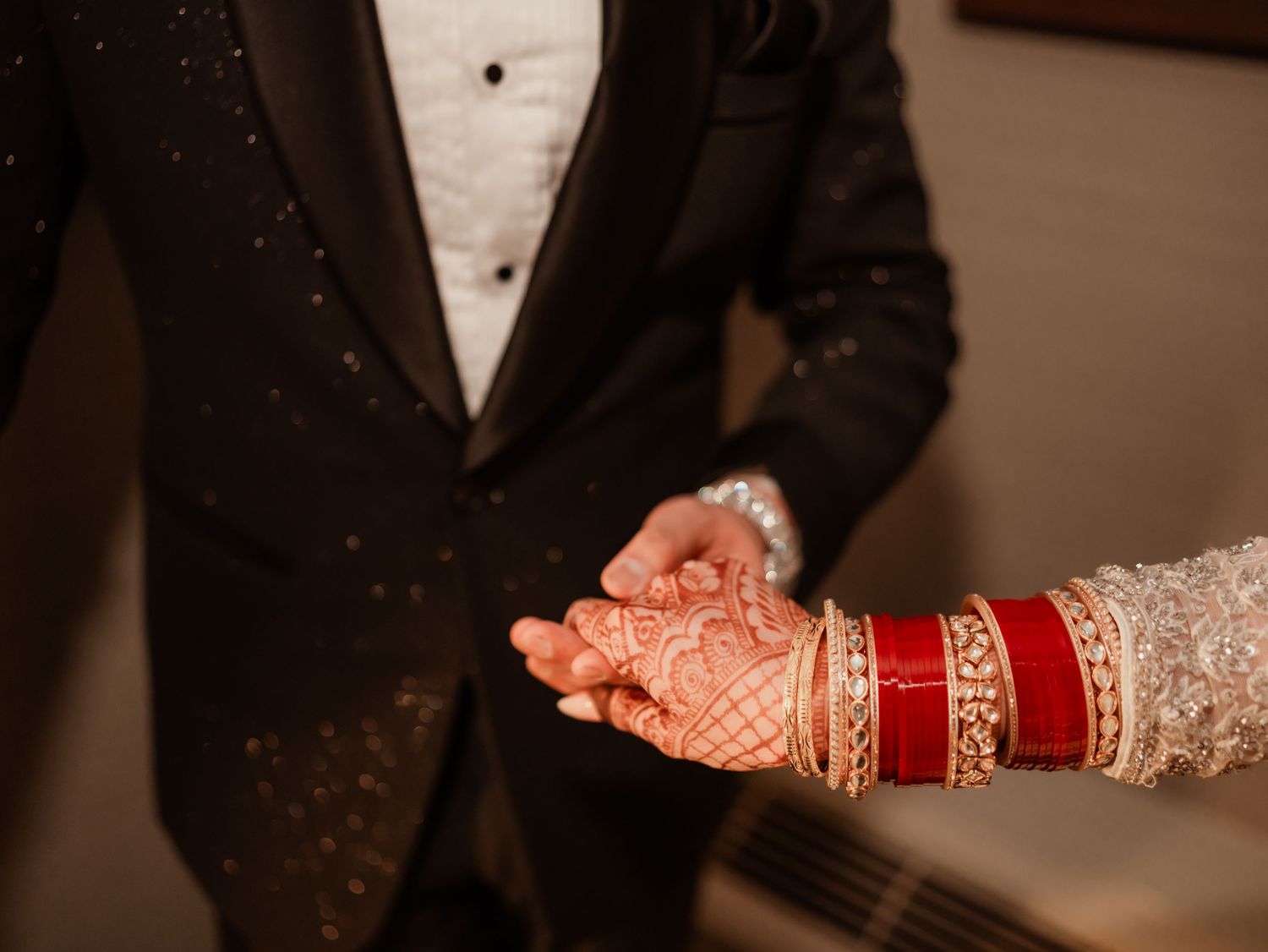 Close-up details of traditional wedding attire including henna and bangles.