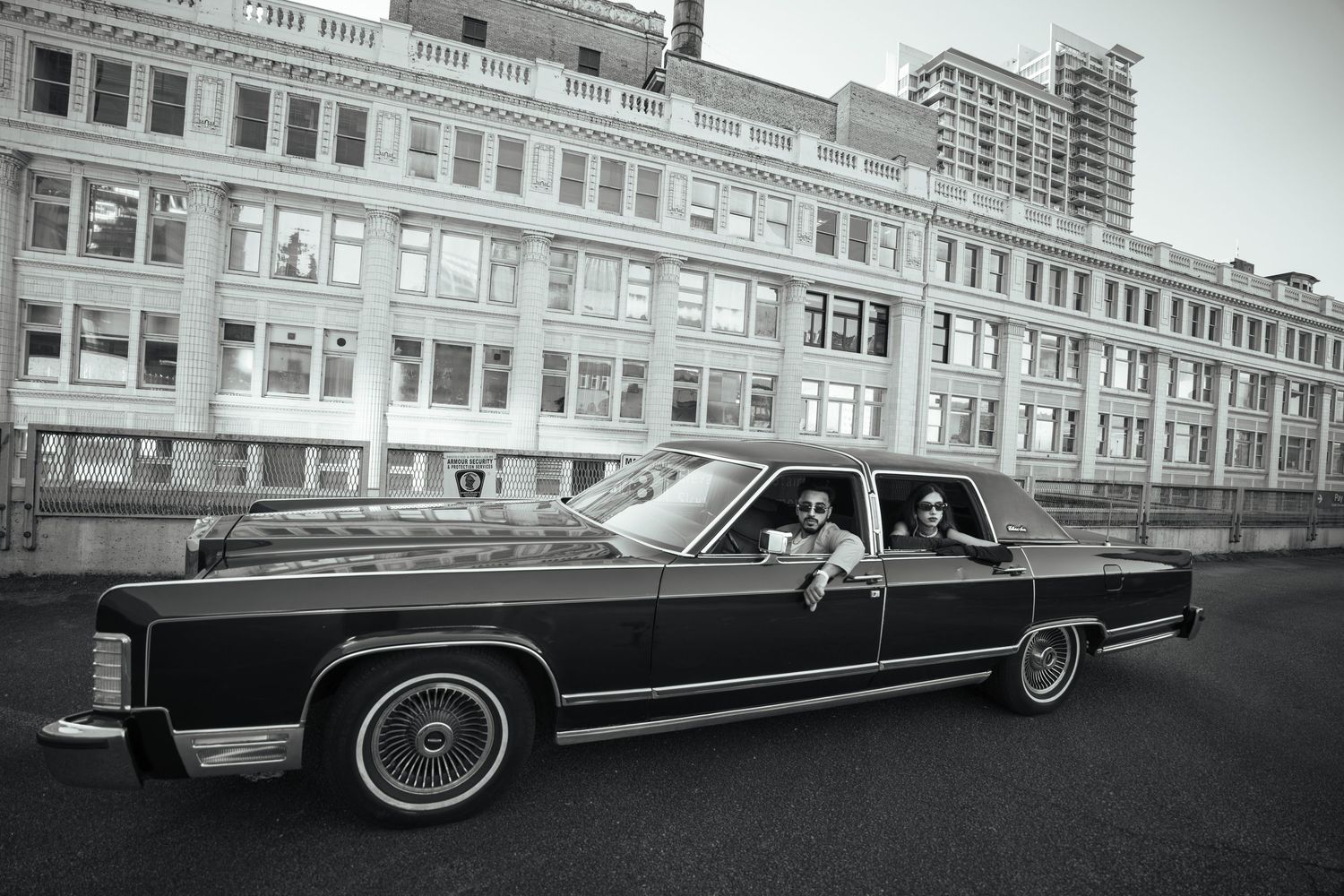 Classic black Lincoln Continental convertible parked on an urban street with historic buildings in the background.