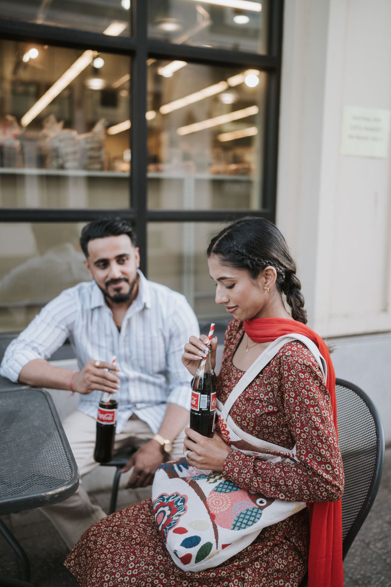 Two people sharing drinks and conversation at a casual office meeting space.