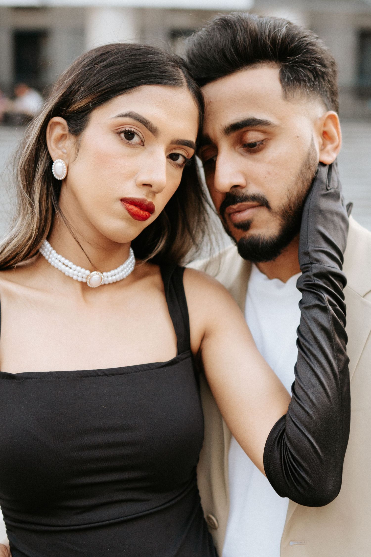 Stylish couple in black and white attire posing together for an intimate portrait.