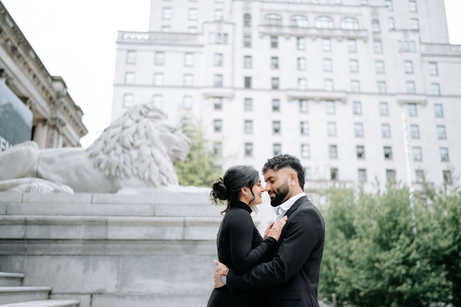 A couple shares a romantic moment on grand stone steps of a historic building.