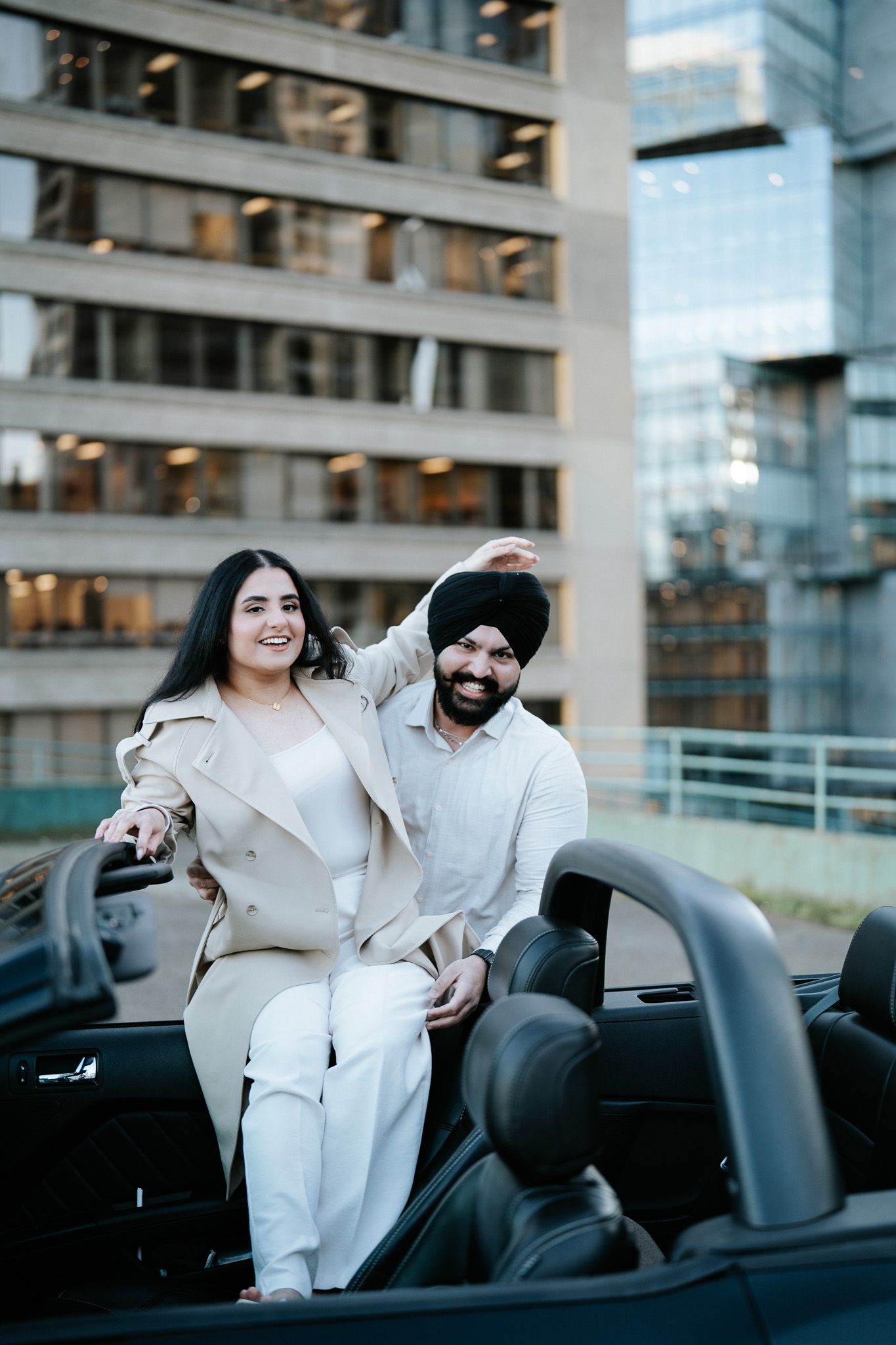 Couple sharing joyful moments together in a luxury convertible car on a sunny day.