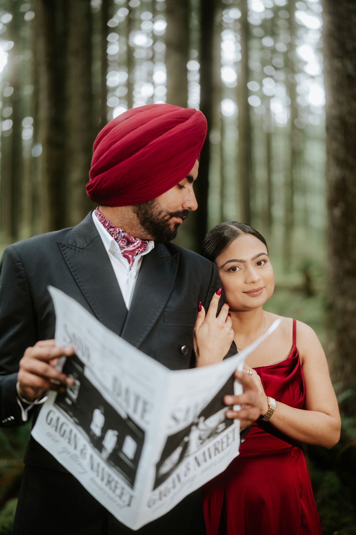 A couple in formal attire reads a newspaper together in a misty forest setting.