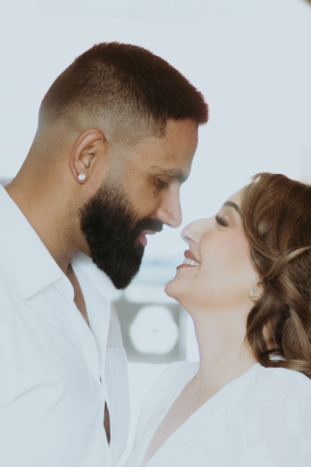 A minimalist photo sequence capturing romantic moments between a couple in white attire.