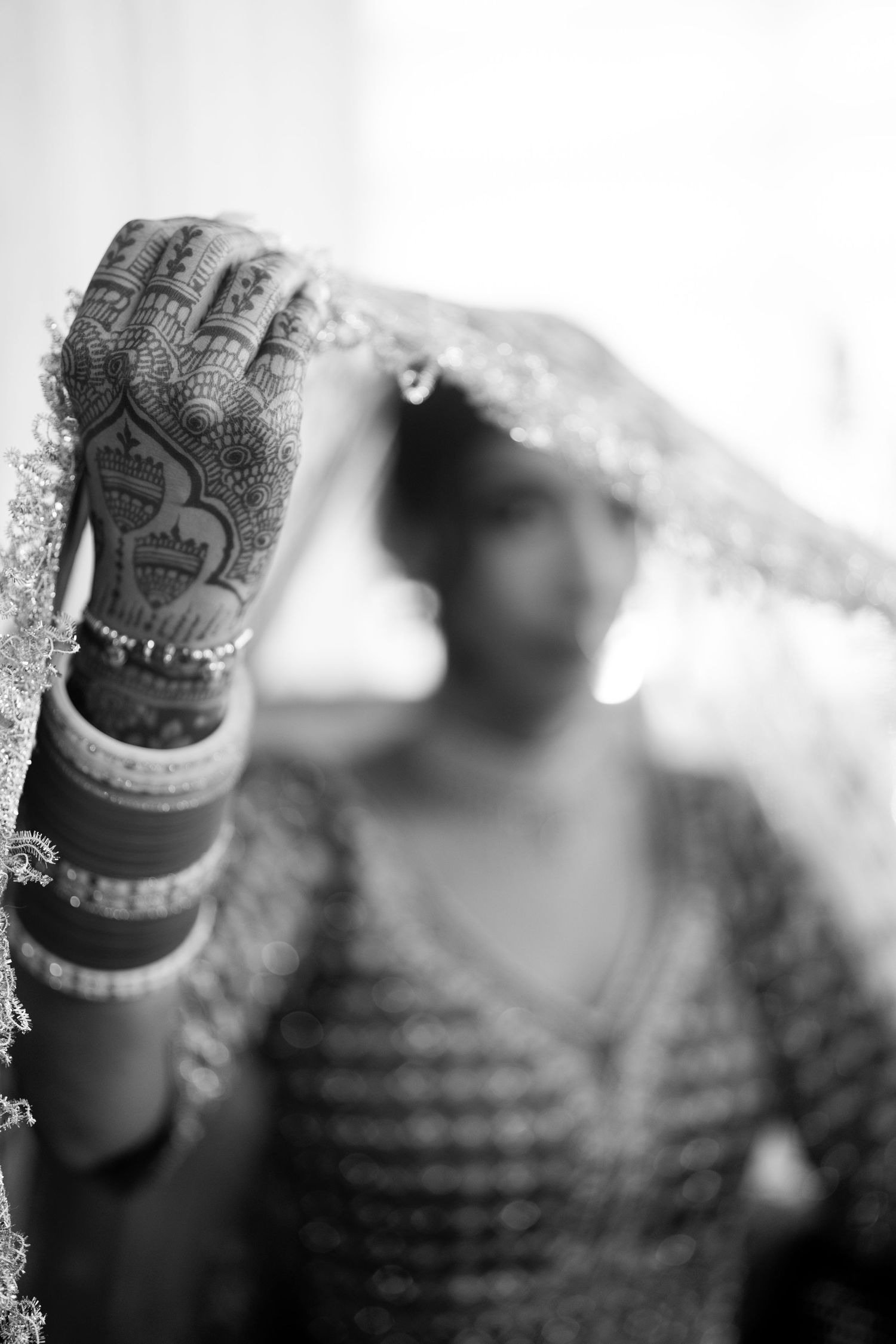 Artistic black and white close-up of traditional Indian bridal details and jewelry.