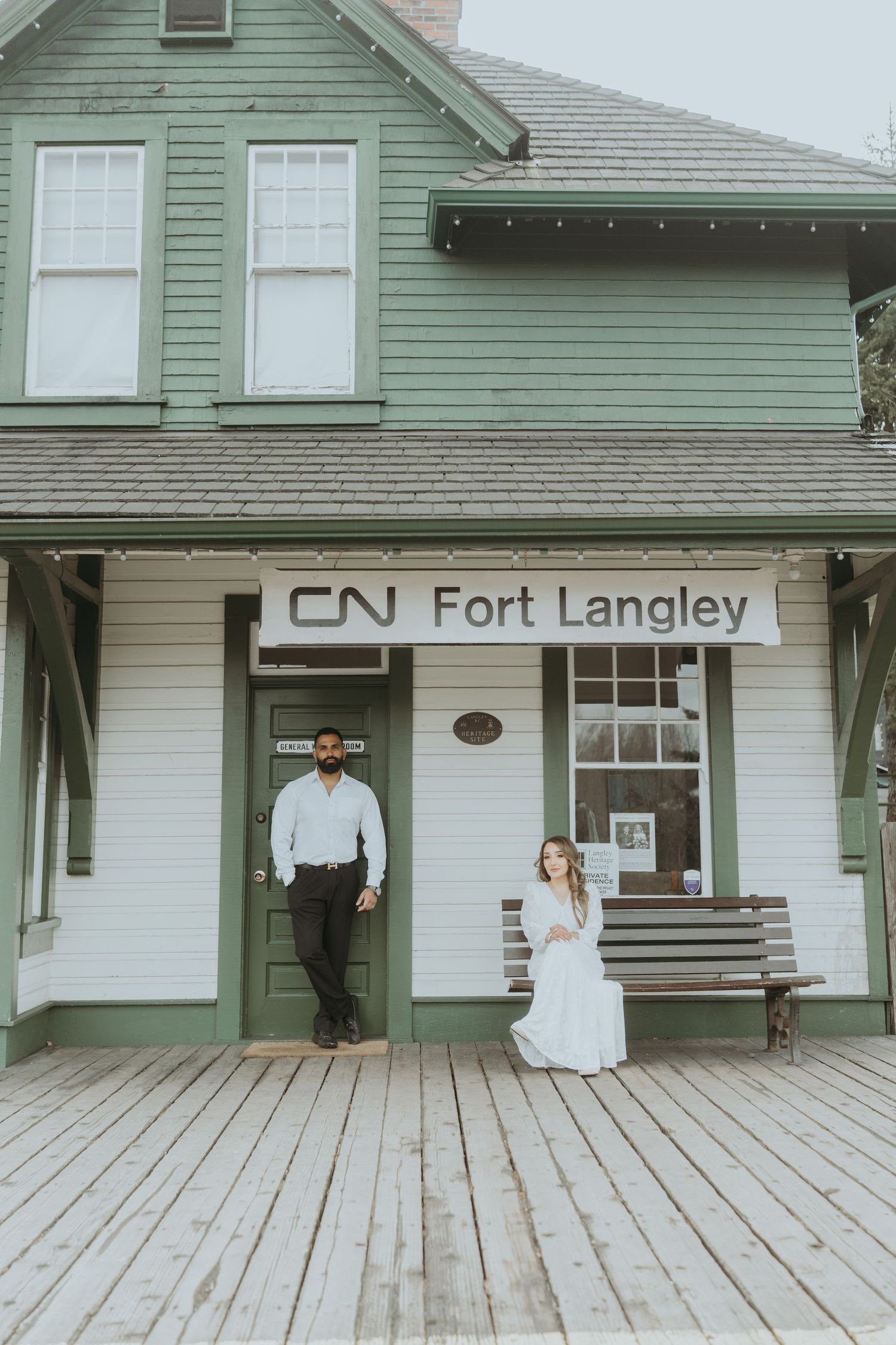 Vintage train station platform with wooden boards and green-painted building exterior at CN Fort Langley.