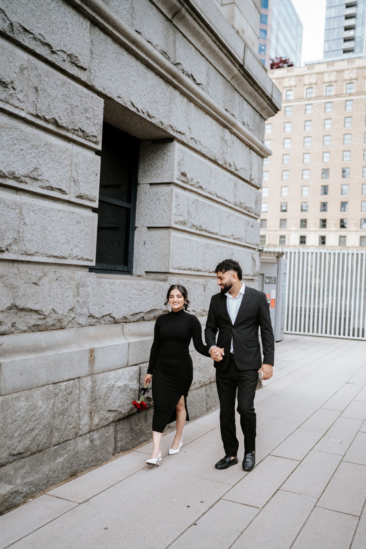 Couple explores architectural space in formal attire during photo session.