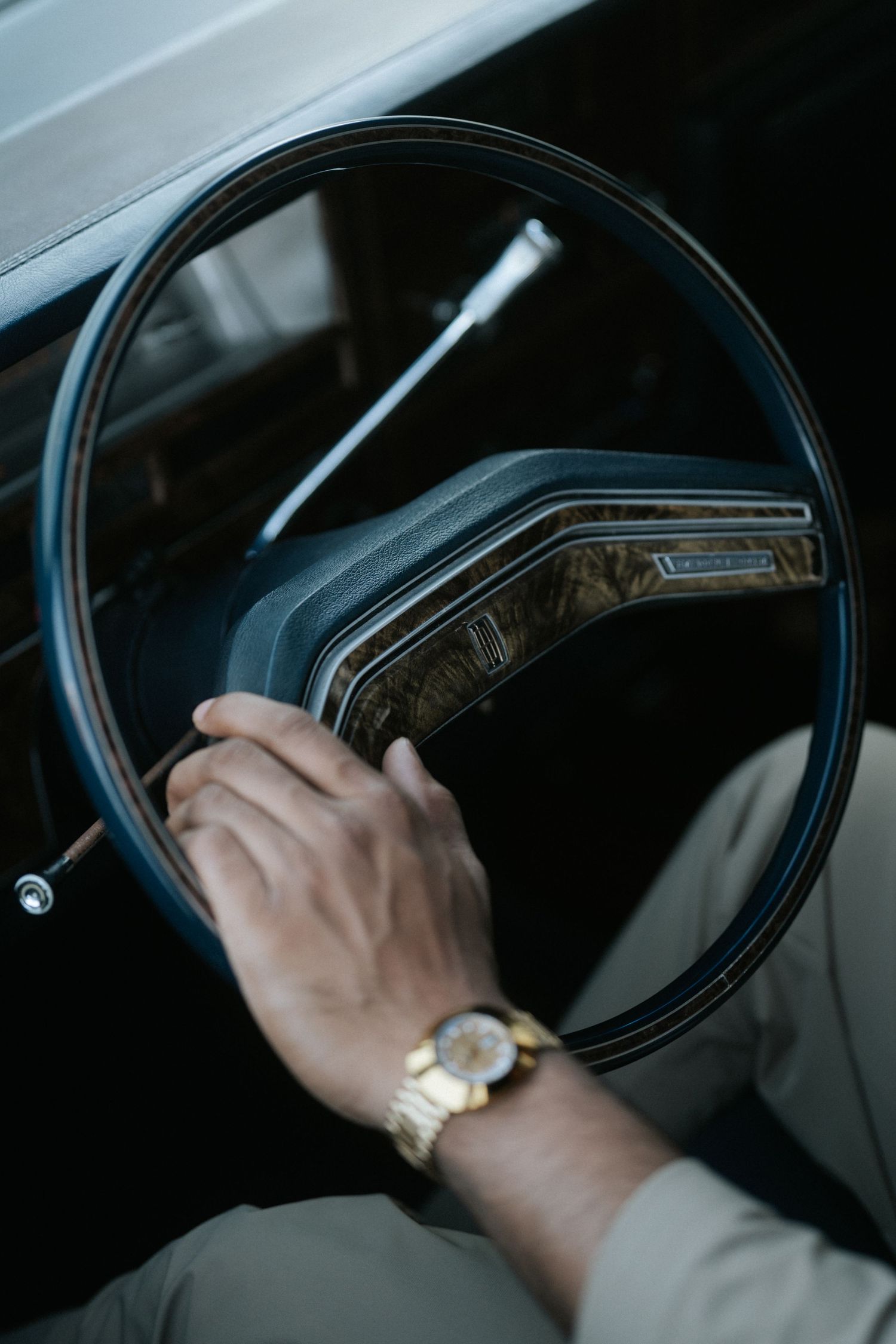 Close-up sequence of hands holding a steering wheel while smoking a cigarette in a dark car interior.
