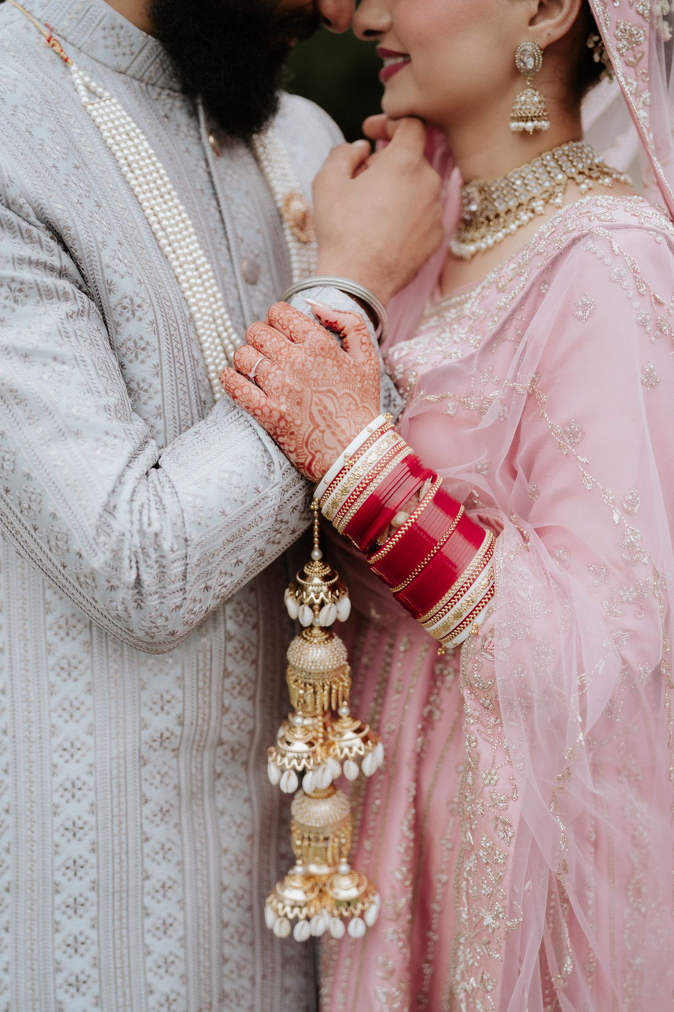 Close-up details of traditional South Asian wedding jewelry and attire in pink and white with ornate embellishments.