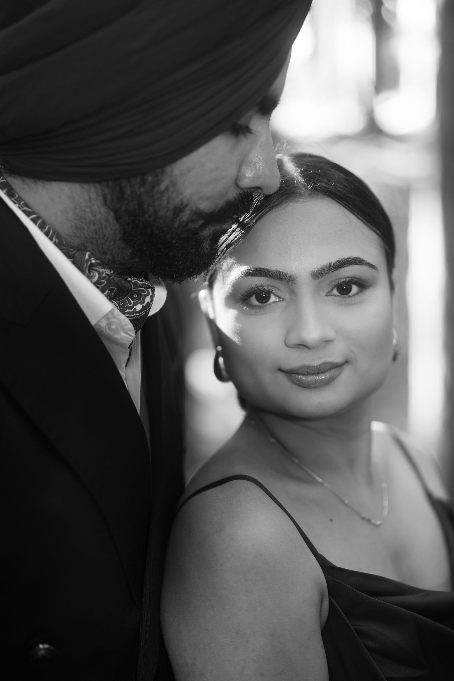 Black and white close-up portrait with dramatic lighting and intimate mood.