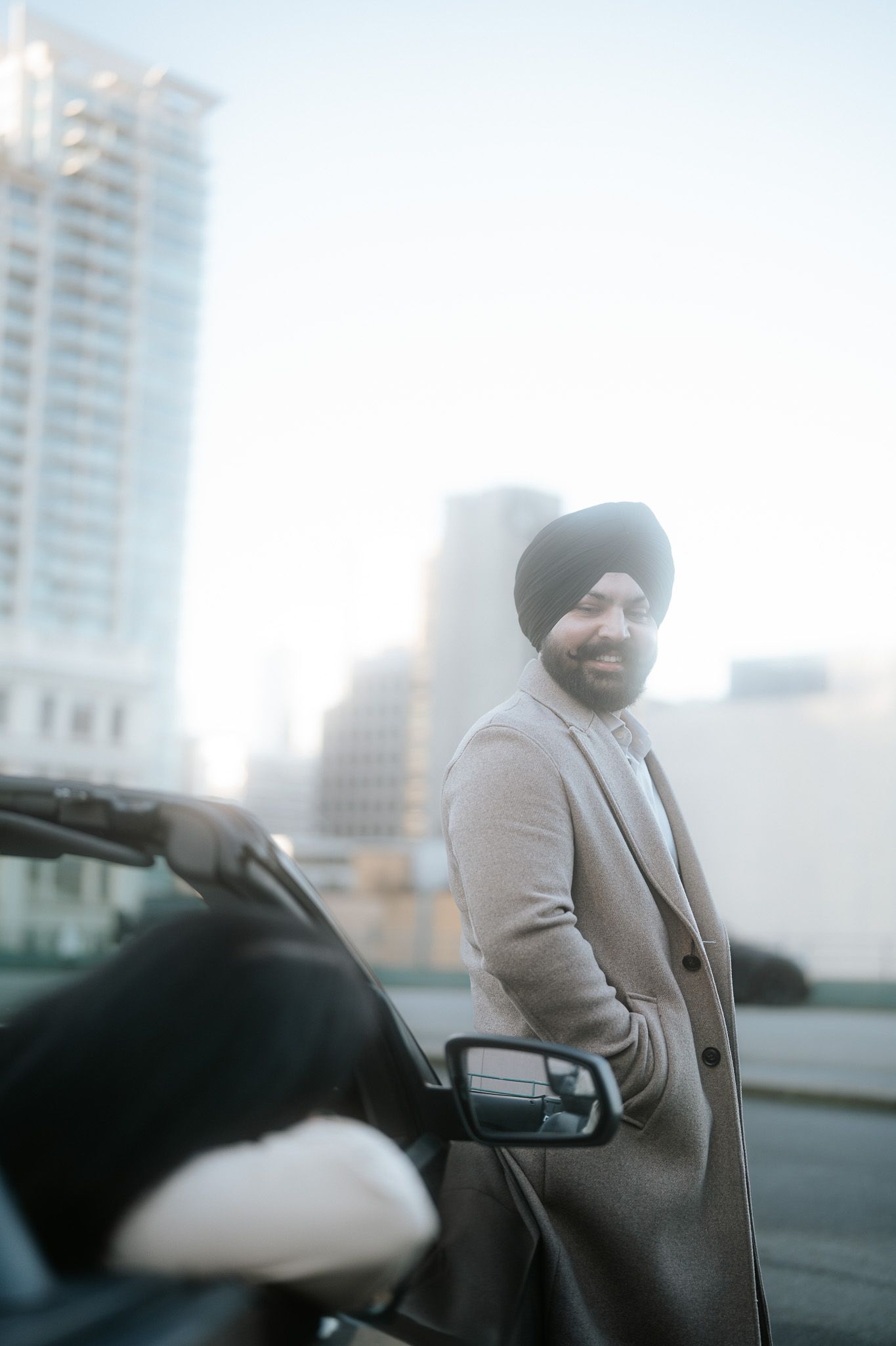 A sequence of motion blur photos showing a person in a light colored coat sitting in a car against an urban backdrop.