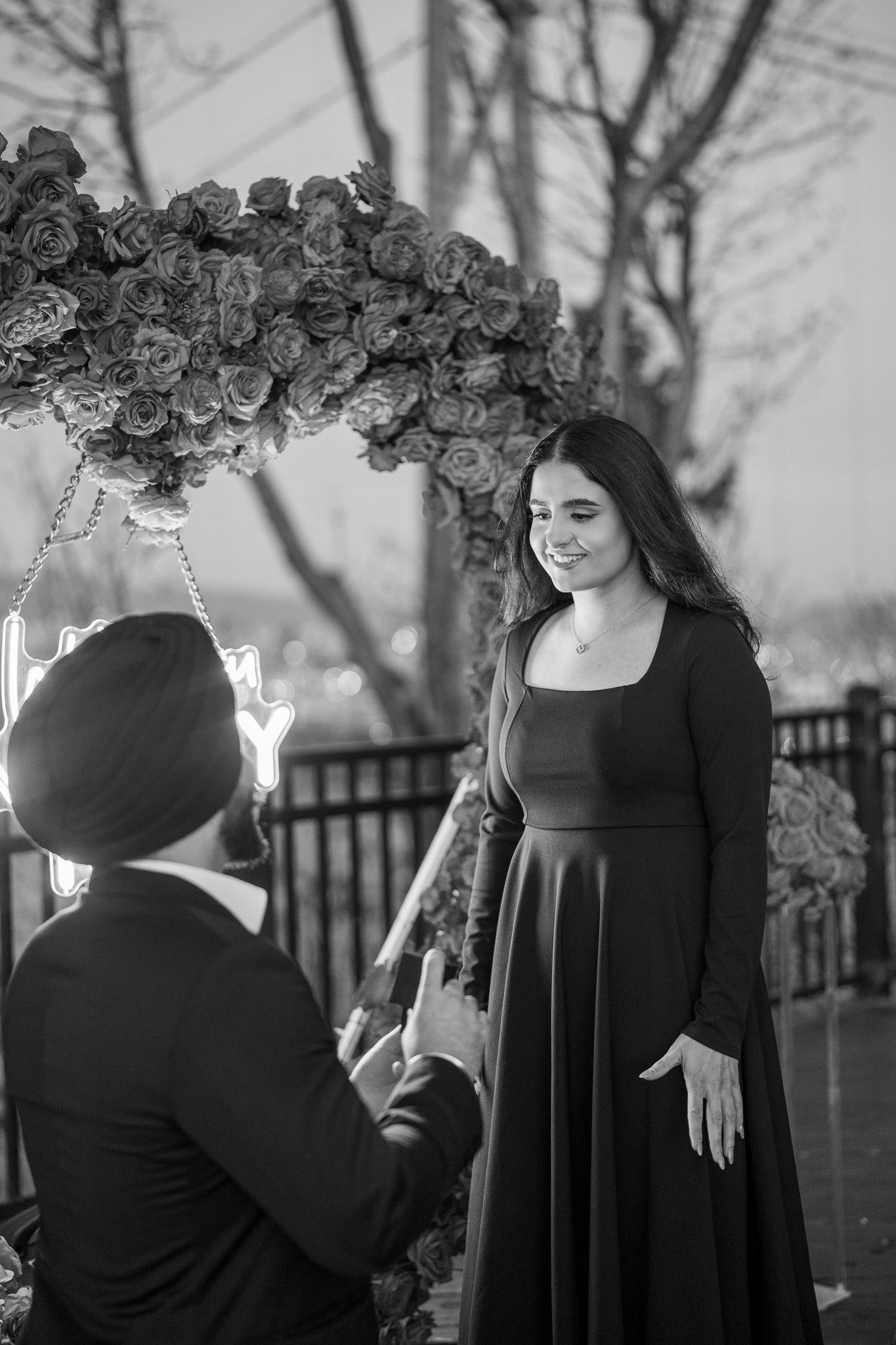 A series of black and white photos showing a person in a black dress wearing a floral crown in various poses.