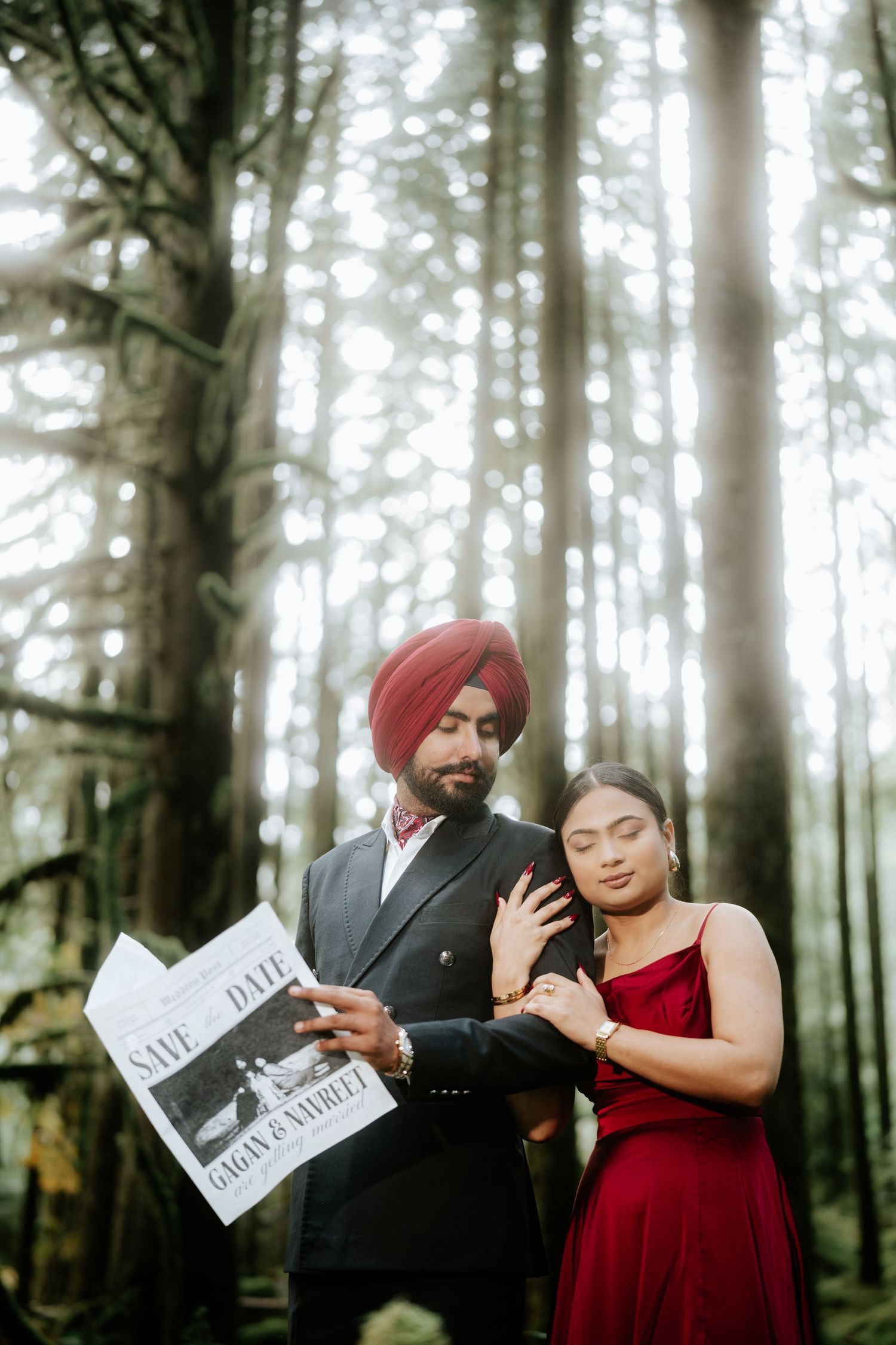 Couple in formal attire reading newspapers during a forest photoshoot.